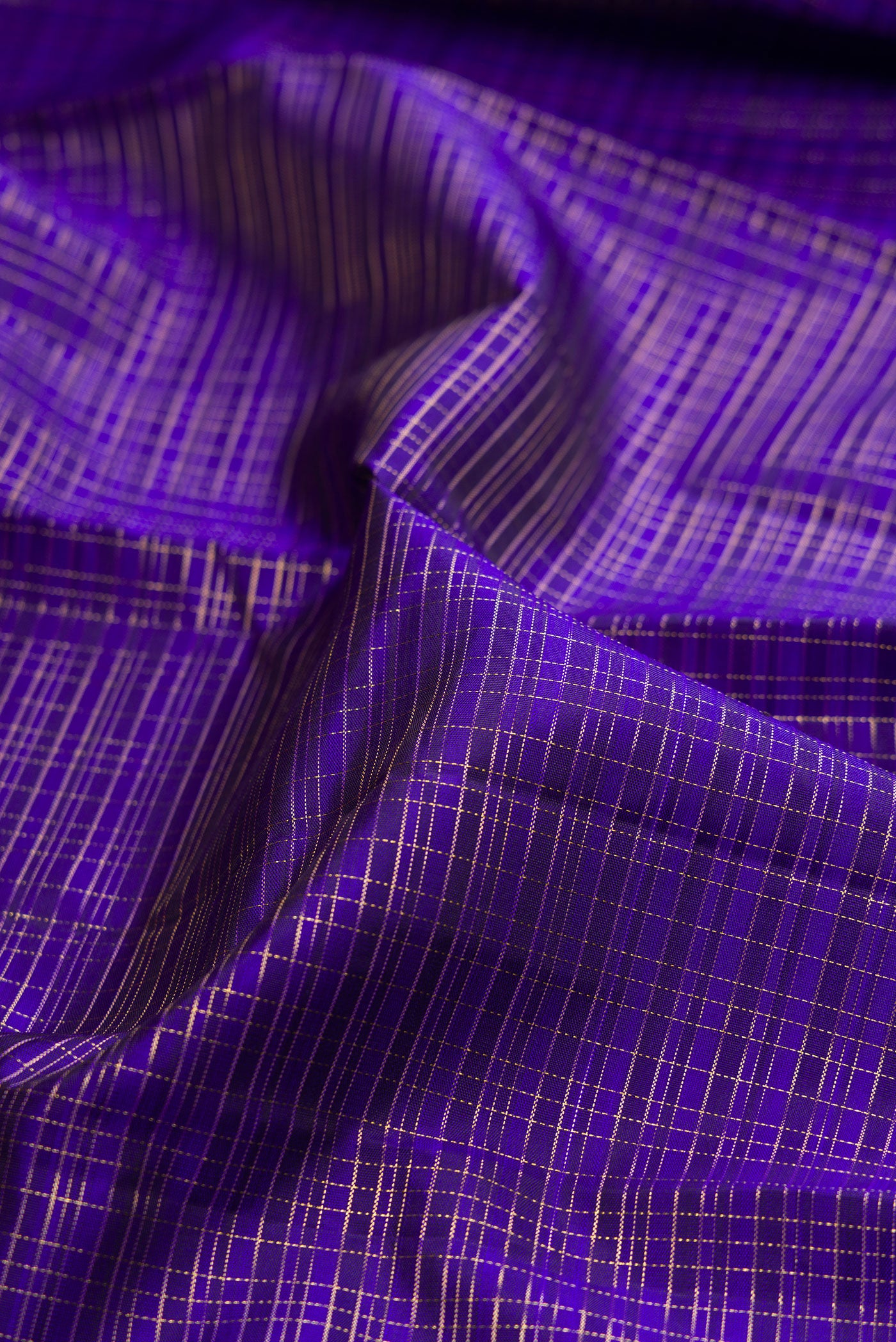 Close up of Royal Blue Kanchipuram Silk Saree with Checked design on the body and Zari Border.  displaying folds