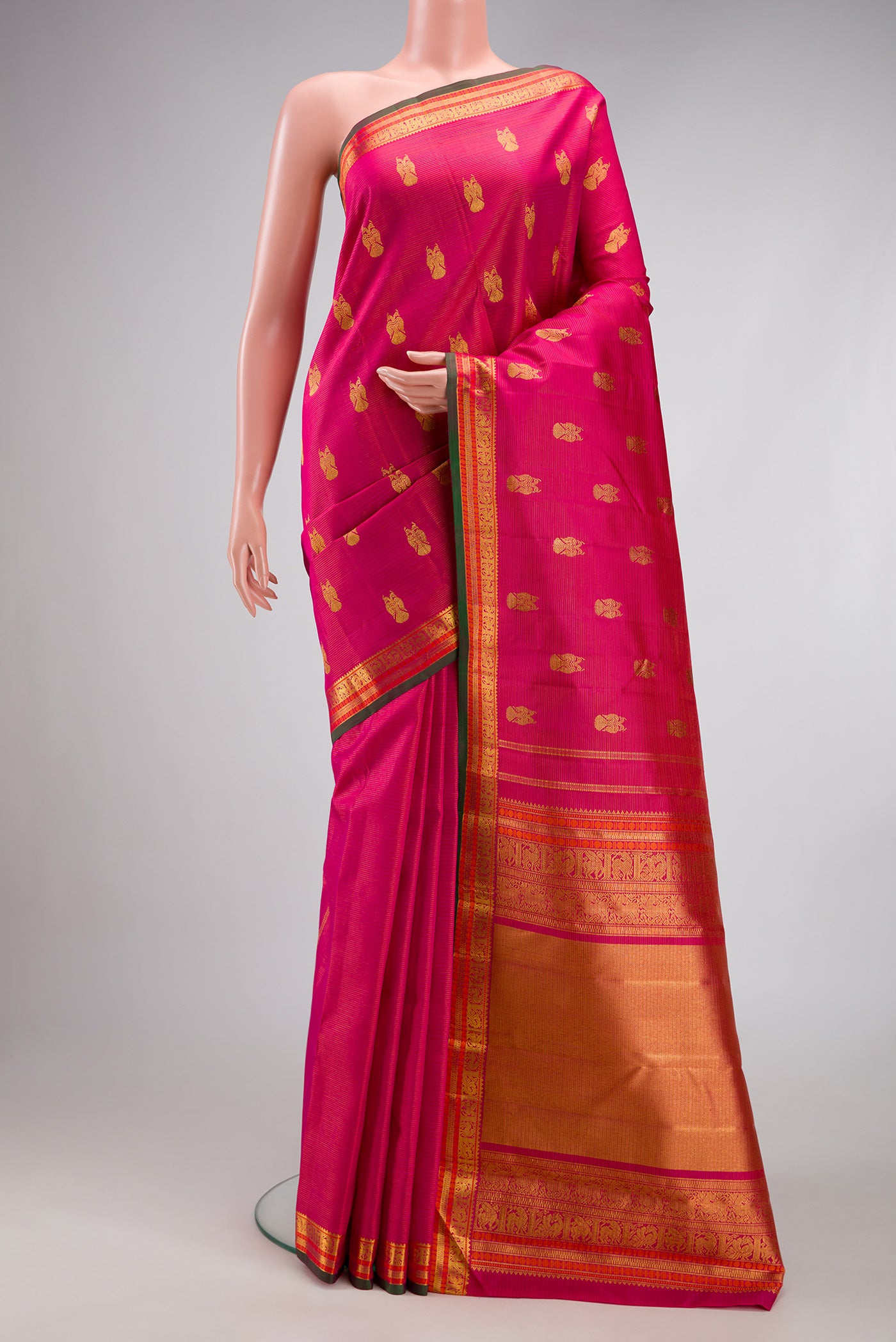 Pink Kanjivaram Silk Saree with Zari Butta on the body and Zari Border.  displayed on a mannequin