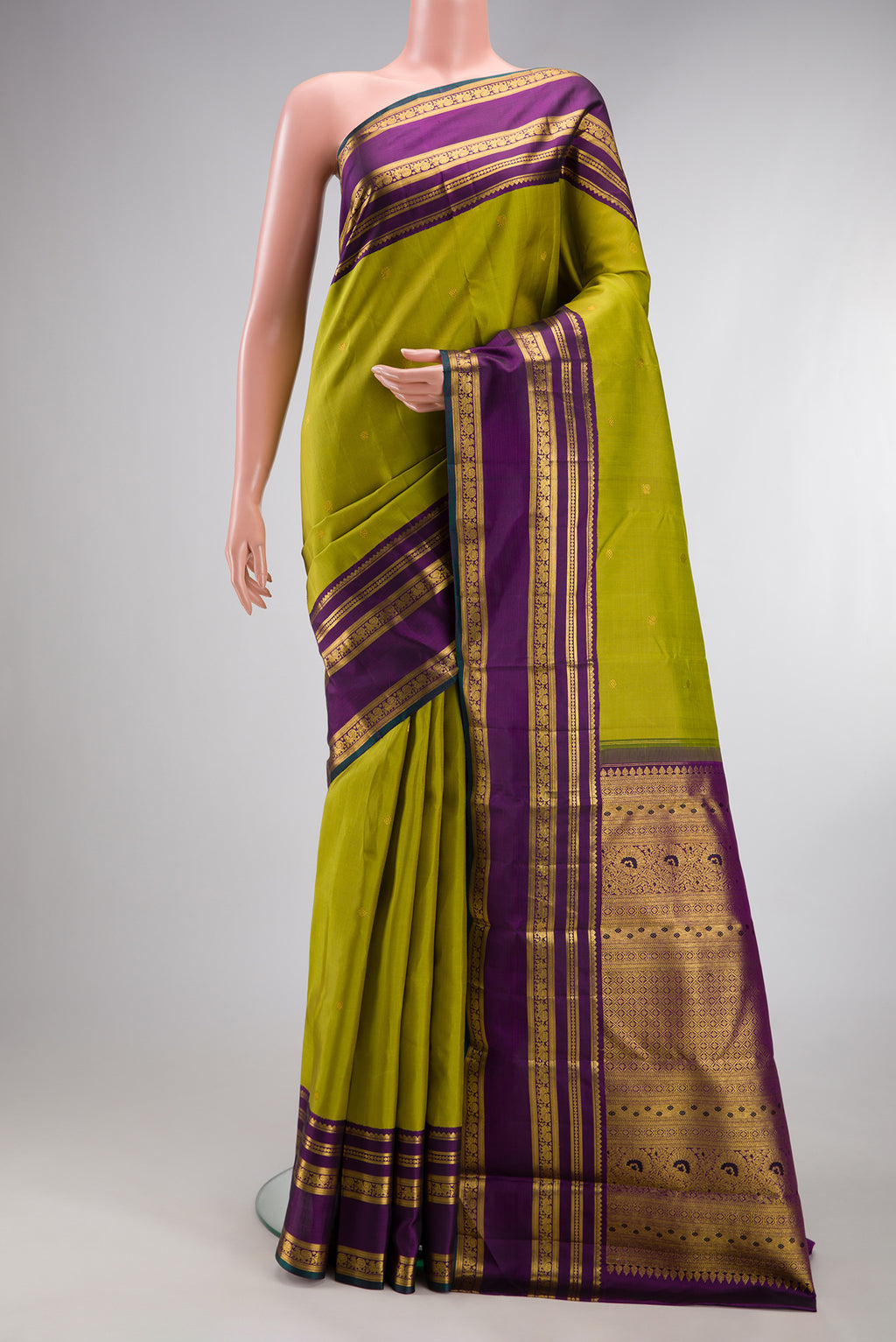 Green Kanchipuram Silk Saree with Zari Butta on the body and Zari Border.  displayed on a mannequin