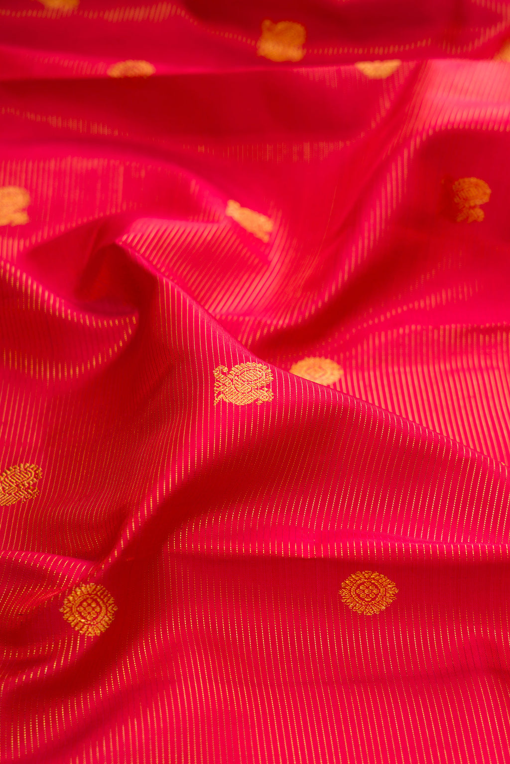 Close up of Red Kanchipuram Silk Saree with Stripes on the body and Zari Border.  displaying folds