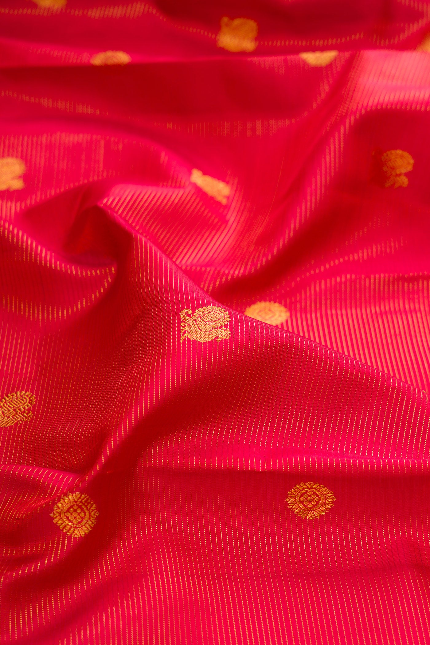 Close up of Red Kanchipuram Silk Saree with Stripes on the body and Zari Border.  displaying folds