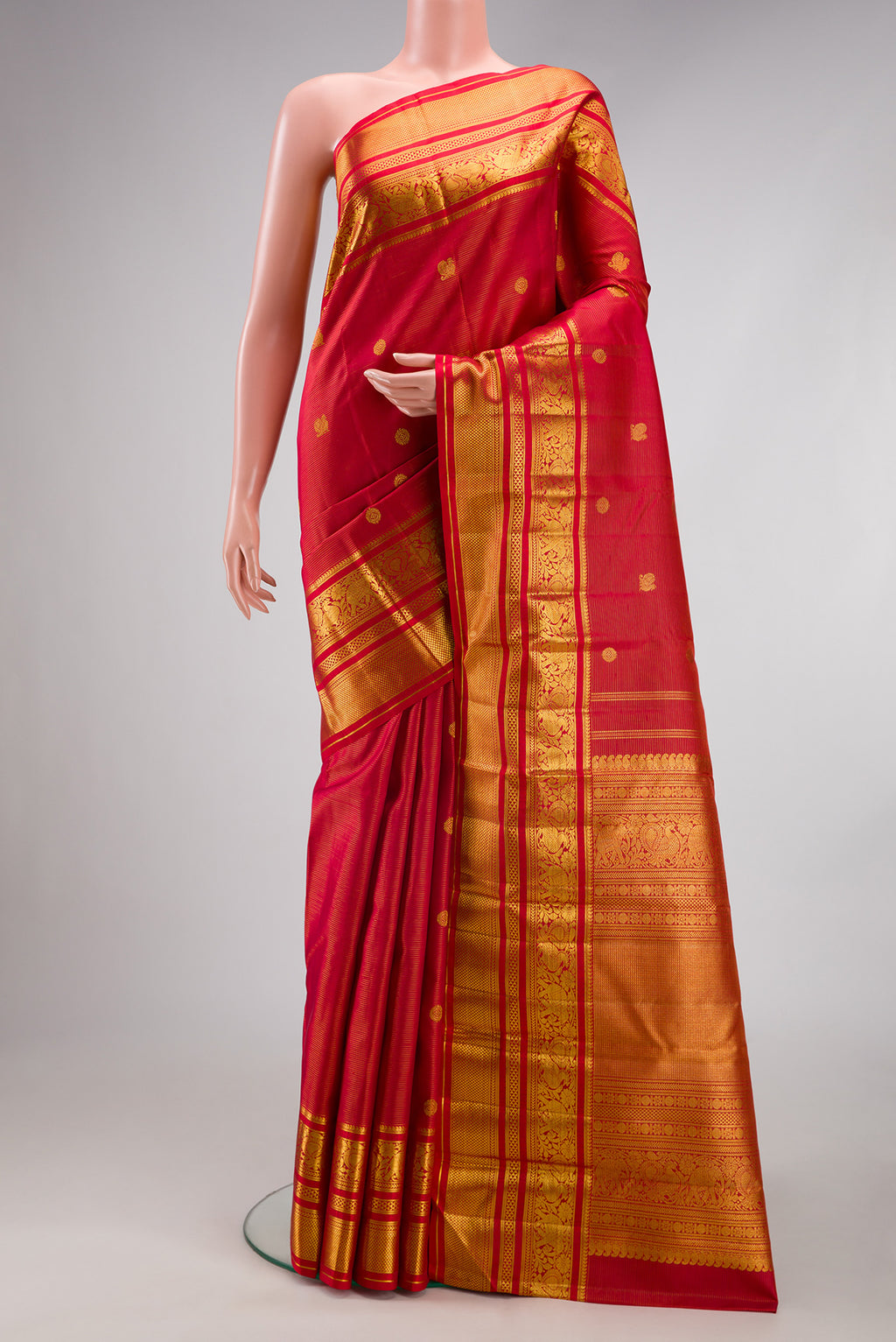 Red Kanchipuram Silk Saree with Stripes on the body and Zari Border.  displayed on a mannequin