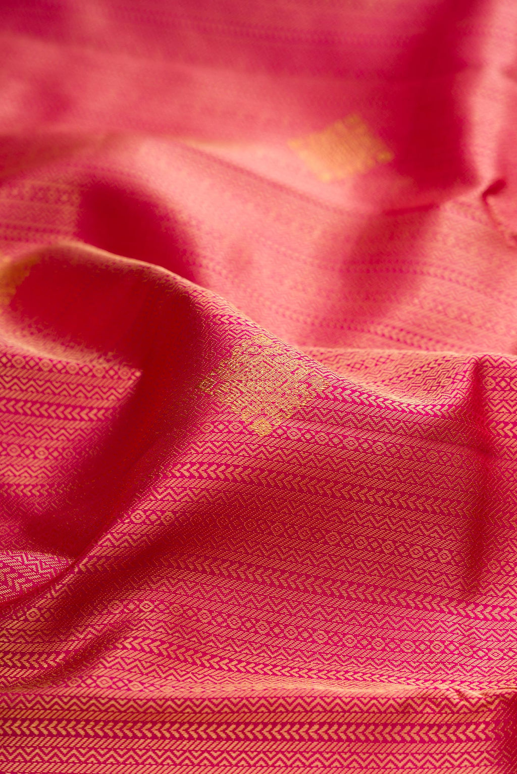 Close up of Pure Silk Dark Pink Kanchipuram Saree with Zari Brocade on the body and Zari Border.  displaying folds