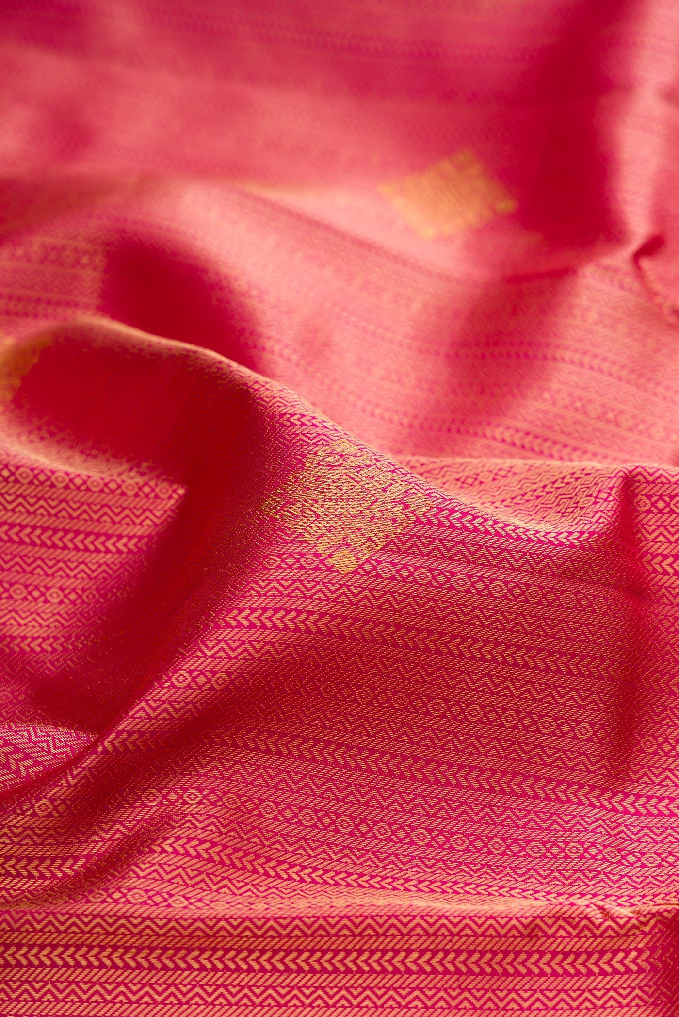 Close up of Pure Silk Dark Pink Kanchipuram Saree with Zari Brocade on the body and Zari Border.  displaying folds