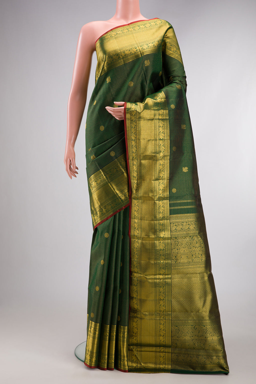 Bottle Green Kanchipuram Silk Saree with Zari Butta on the body and Zari Border.  displayed on a mannequin