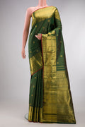 Bottle Green Kanchipuram Silk Saree with Zari Butta on the body and Zari Border.  displayed on a mannequin
