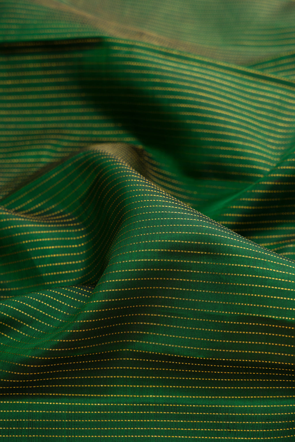 Close up of Bottle Green Kanchipuram Silk Saree with Stripes on the body and Fancy Border.  displaying folds