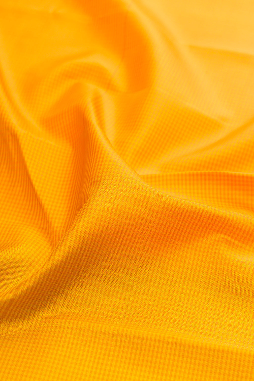Close up of Yellow Kanjivaram Silk Saree with Checked design on the body and Zari Border.  displaying folds