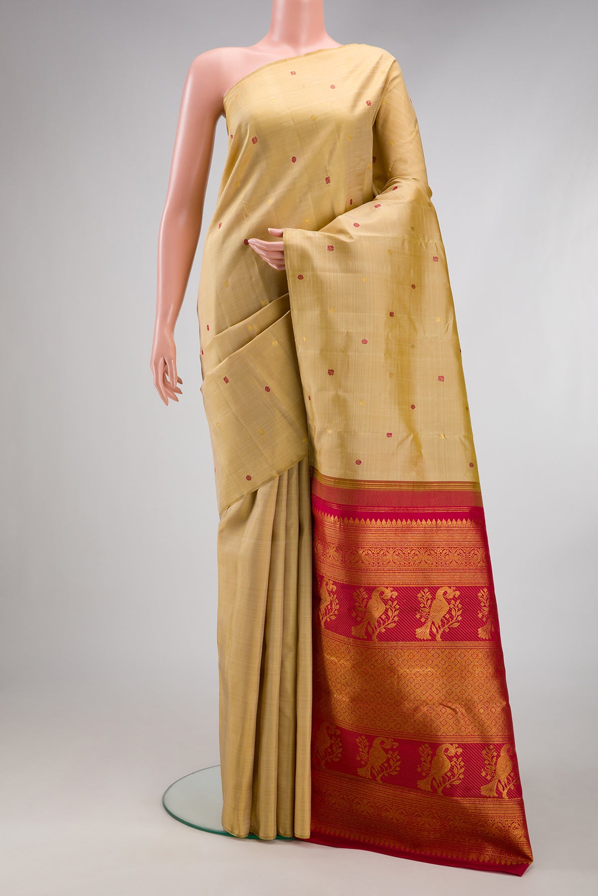 Beige Kanjivaram Silk Saree with Zari And Thread Butta on the body and Without Border.  displayed on a mannequin