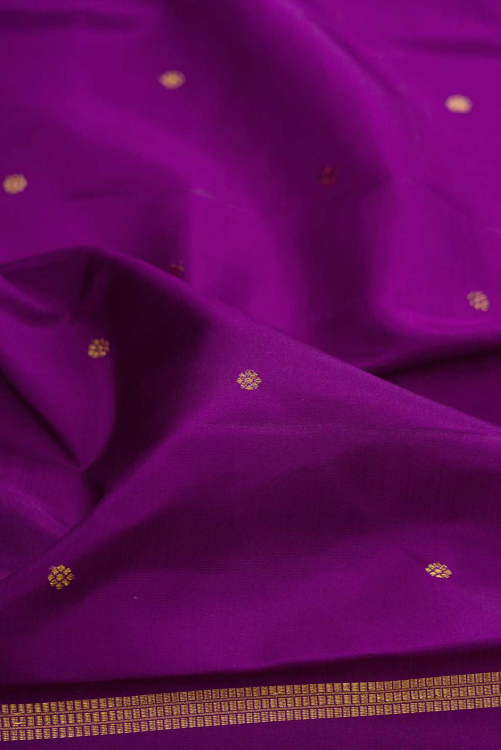 Close up of Purple Kanjivaram Silk Saree with Zari Butta on the body and Fancy Border.  displaying folds