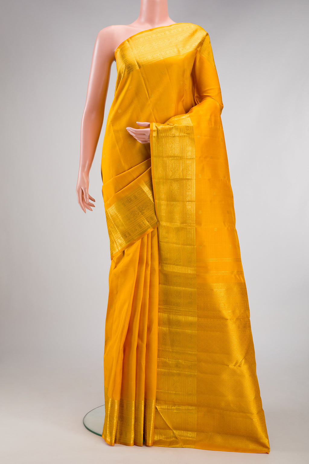 Yellow Kanjivaram Silk Saree with Zari Butta on the body and Zari Border.  displayed on a mannequin
