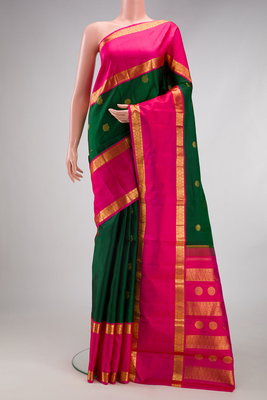 Bottle Green Kanchipuram Silk Saree with Zari Butta on the body and Zari Border.  displayed on a mannequin