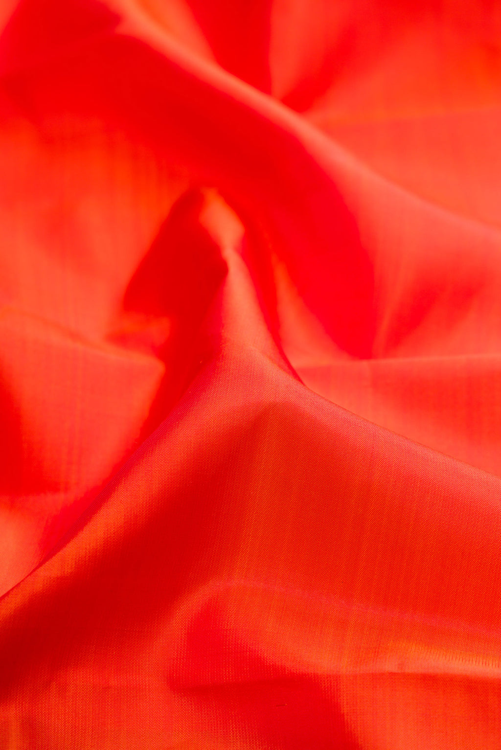 Close up of Orange Kanchipuram Silk Saree with Plain Body and Fancy Border.  displaying folds