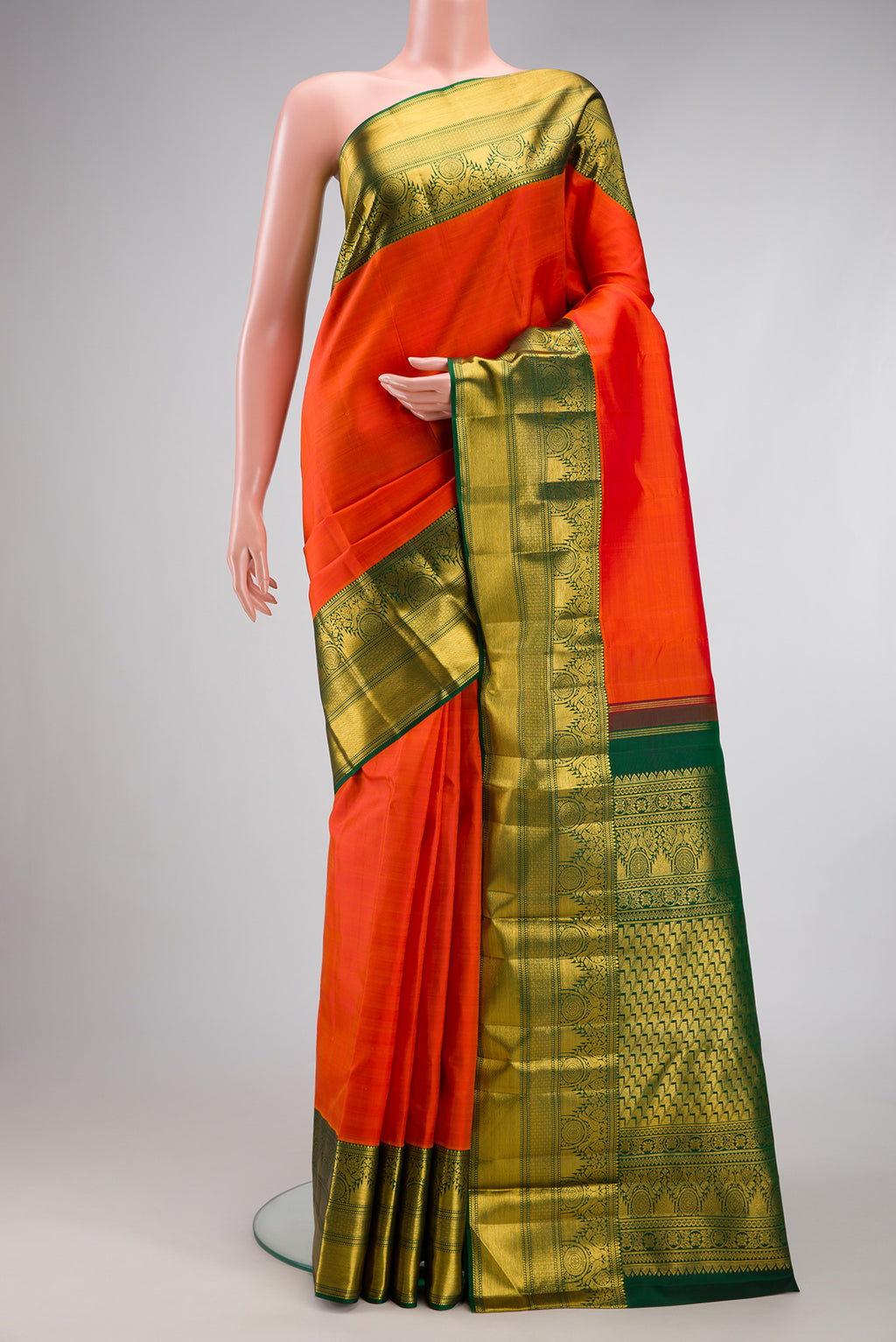 Orange Kanchipuram Silk Saree with Plain Body and Fancy Border.  displayed on a mannequin