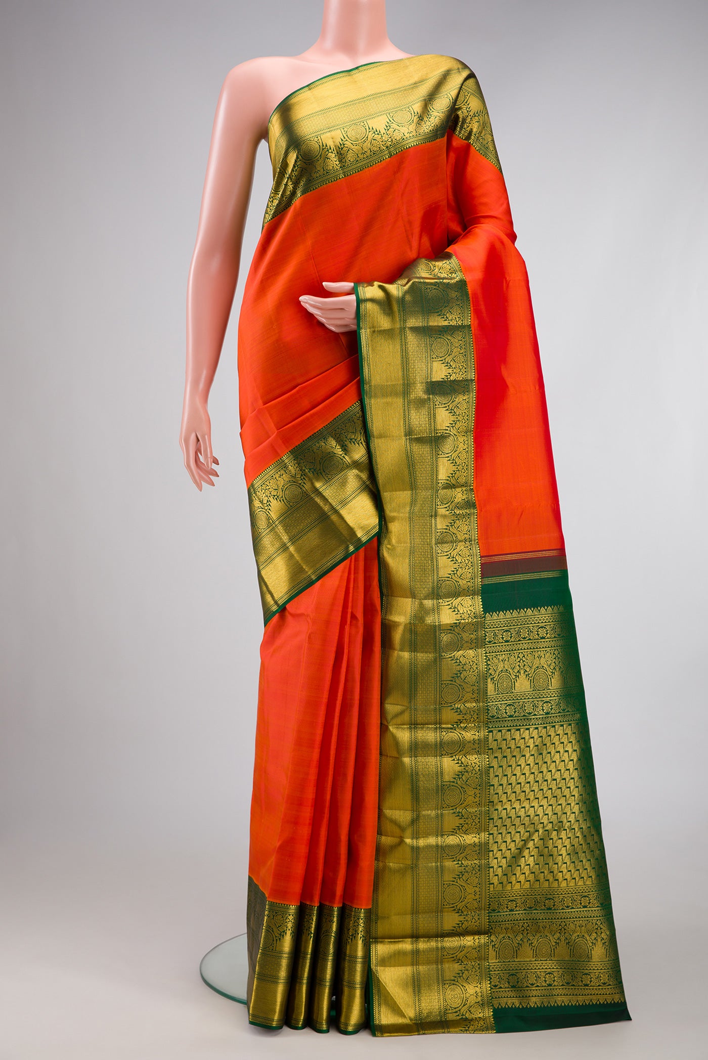 Orange Kanchipuram Silk Saree with Plain Body and Fancy Border.  displayed on a mannequin