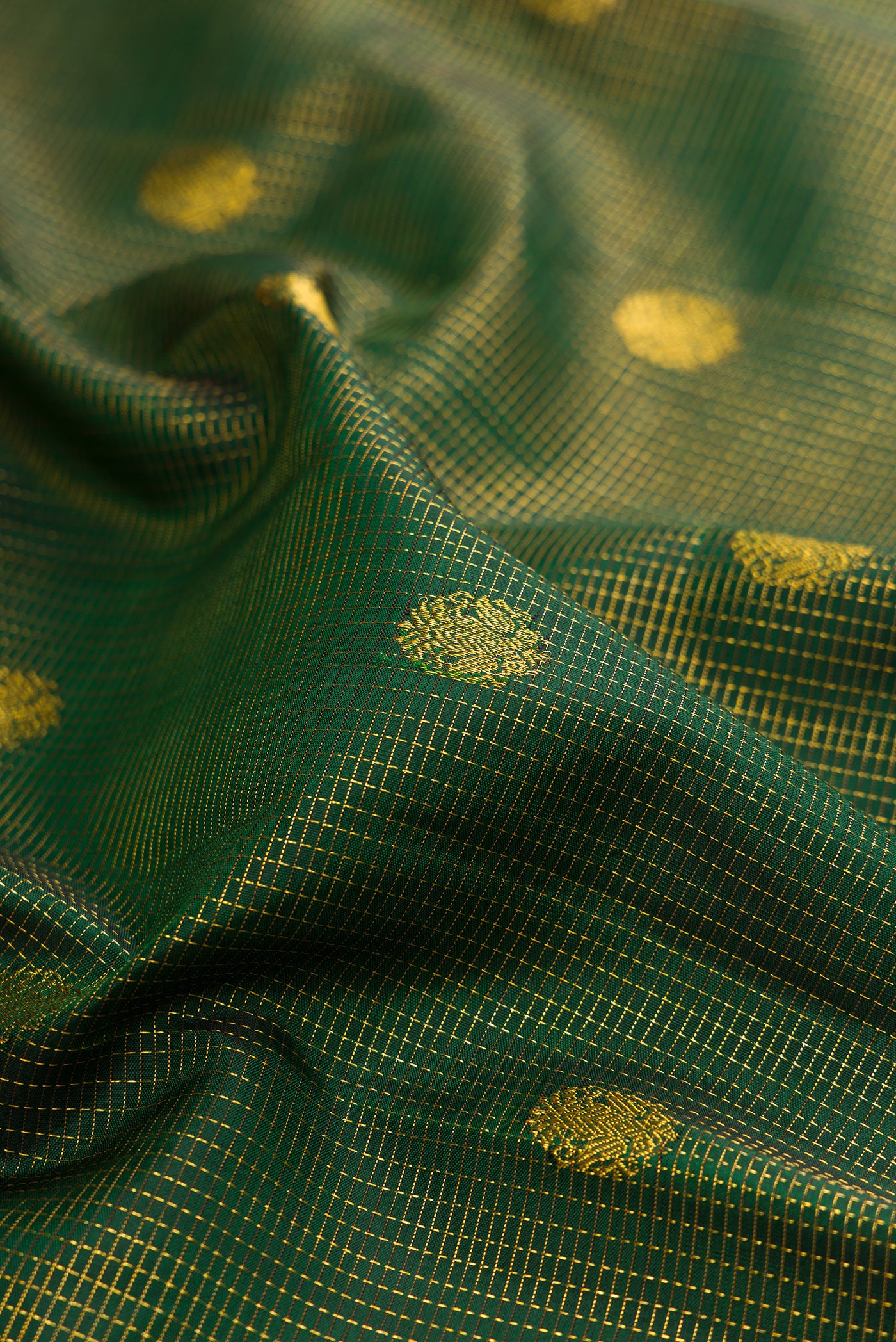 Close up of Bottle Green Kanchipuram Silk Saree with Checked design on the body and Fancy Border.  displaying folds