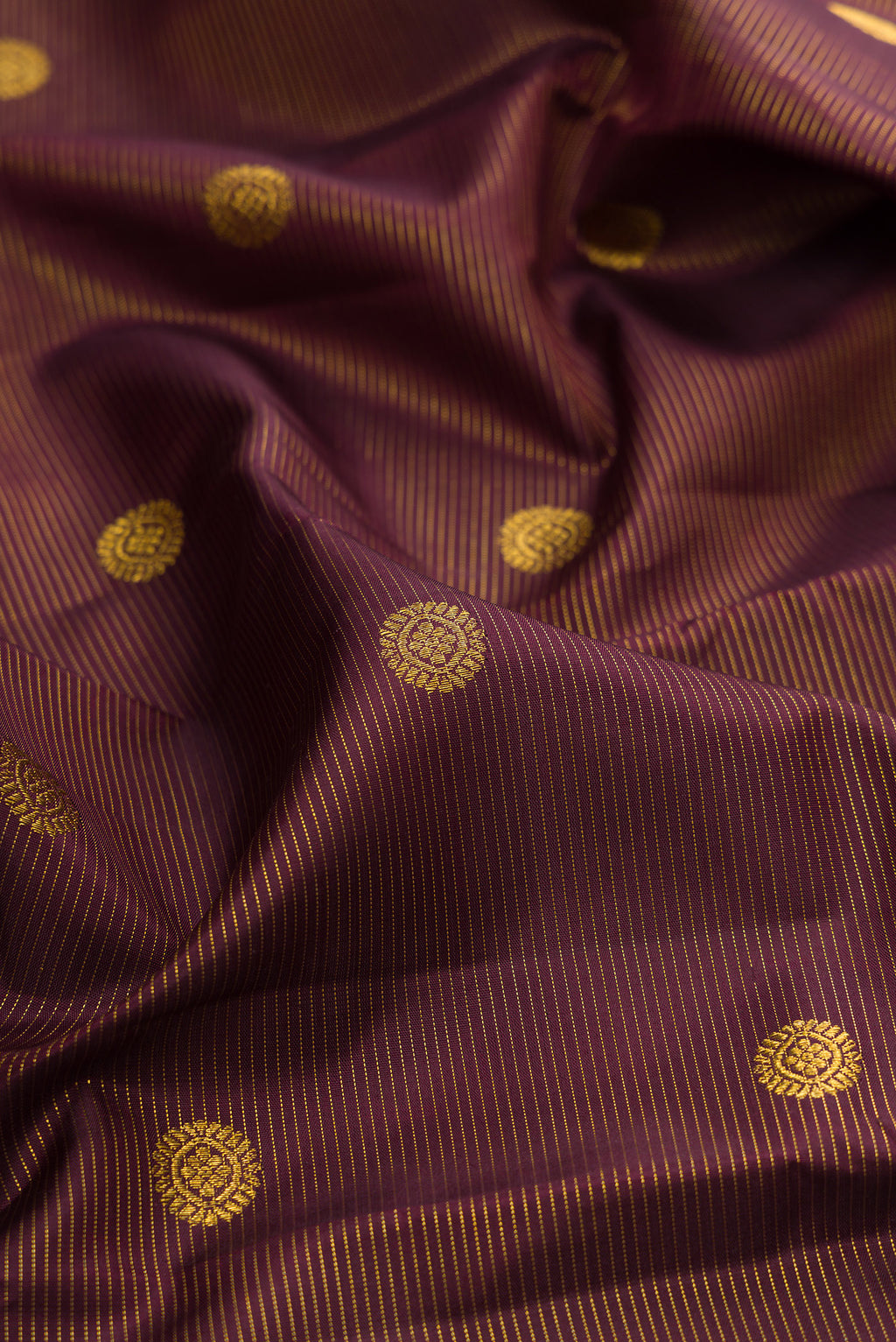 Close up of Brown Kanchipuram Silk Saree with Zari Butta on the body and Zari Border.  displaying folds