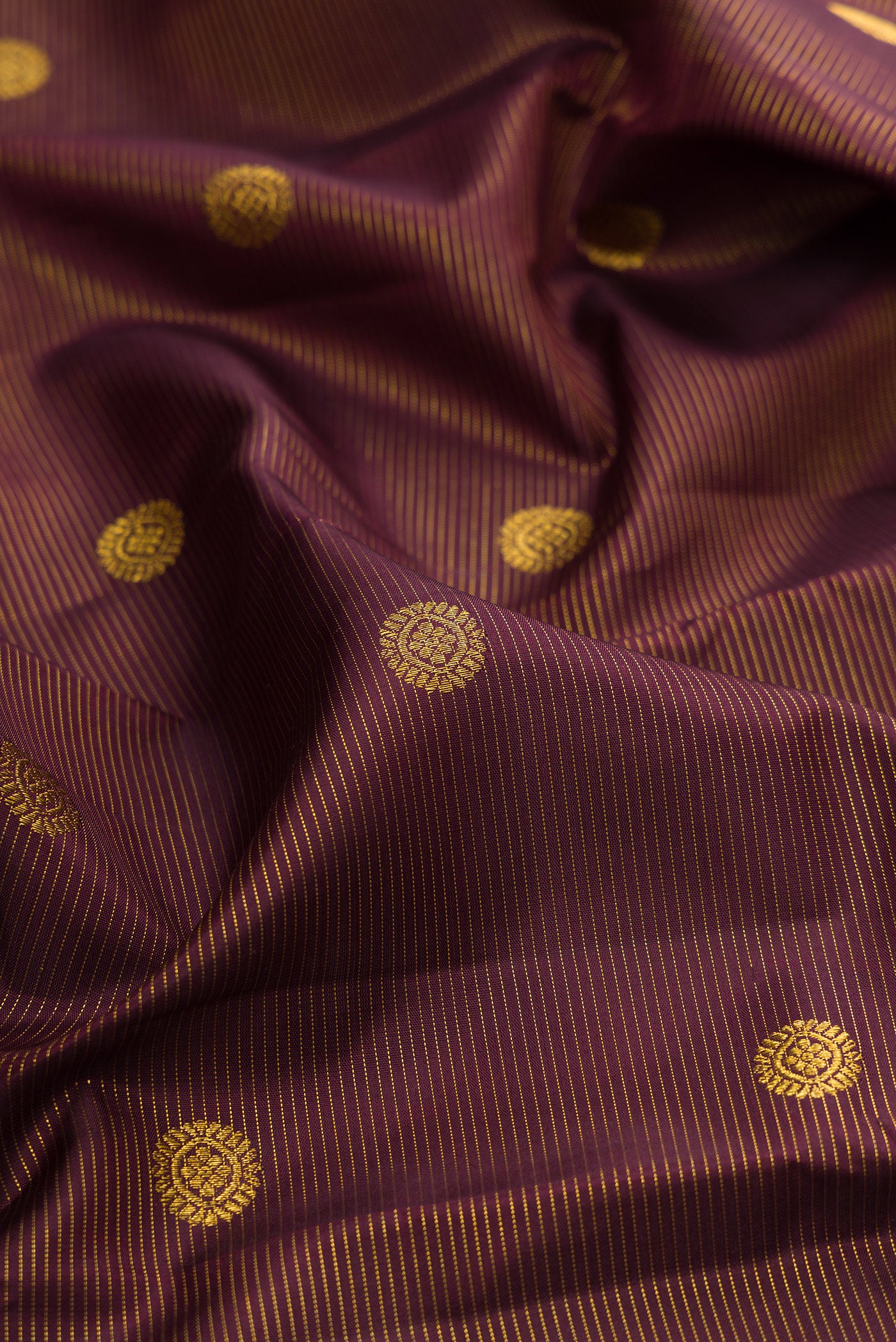 Close up of Brown Kanchipuram Silk Saree with Zari Butta on the body and Zari Border.  displaying folds
