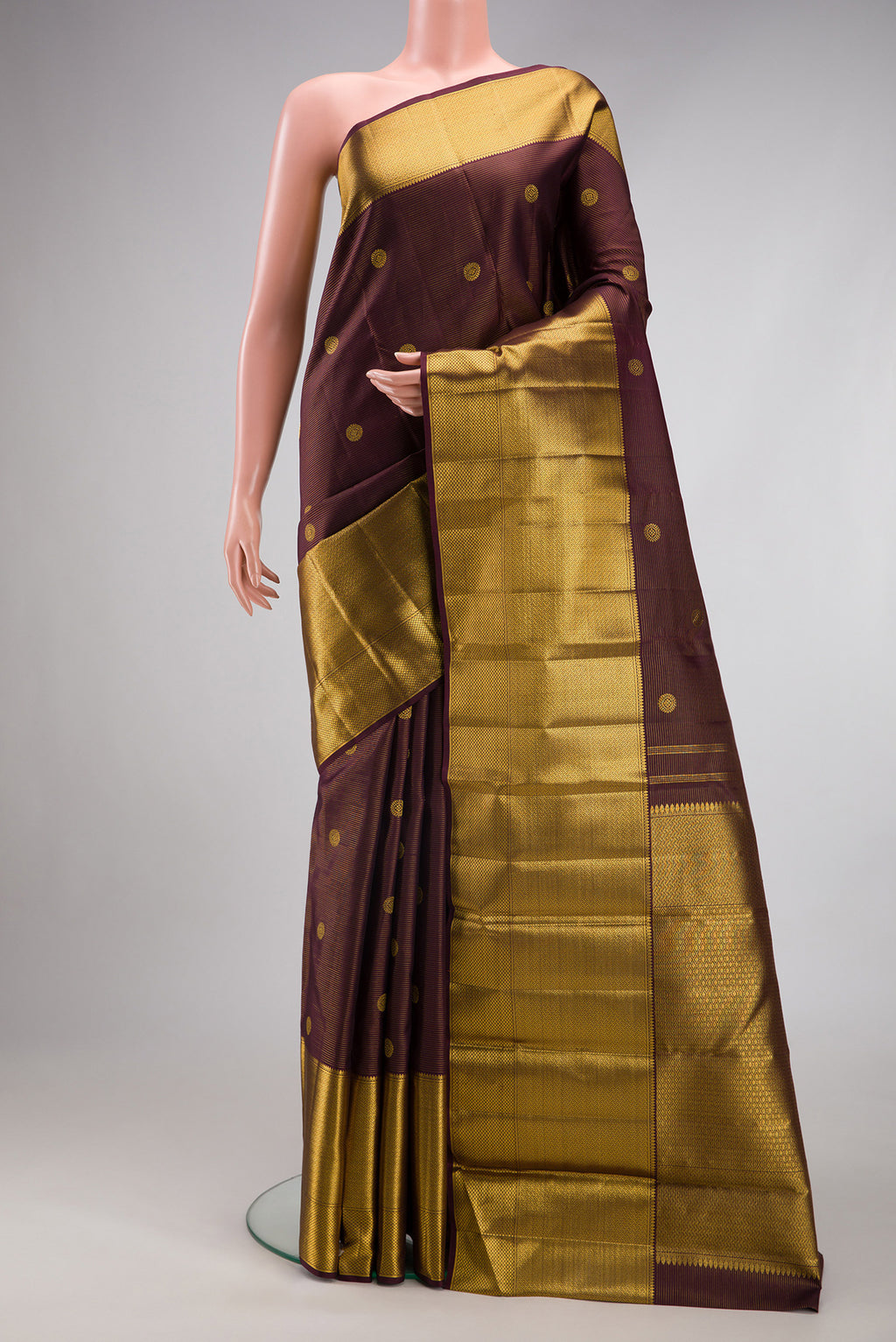 Brown Kanchipuram Silk Saree with Zari Butta on the body and Zari Border.  displayed on a mannequin