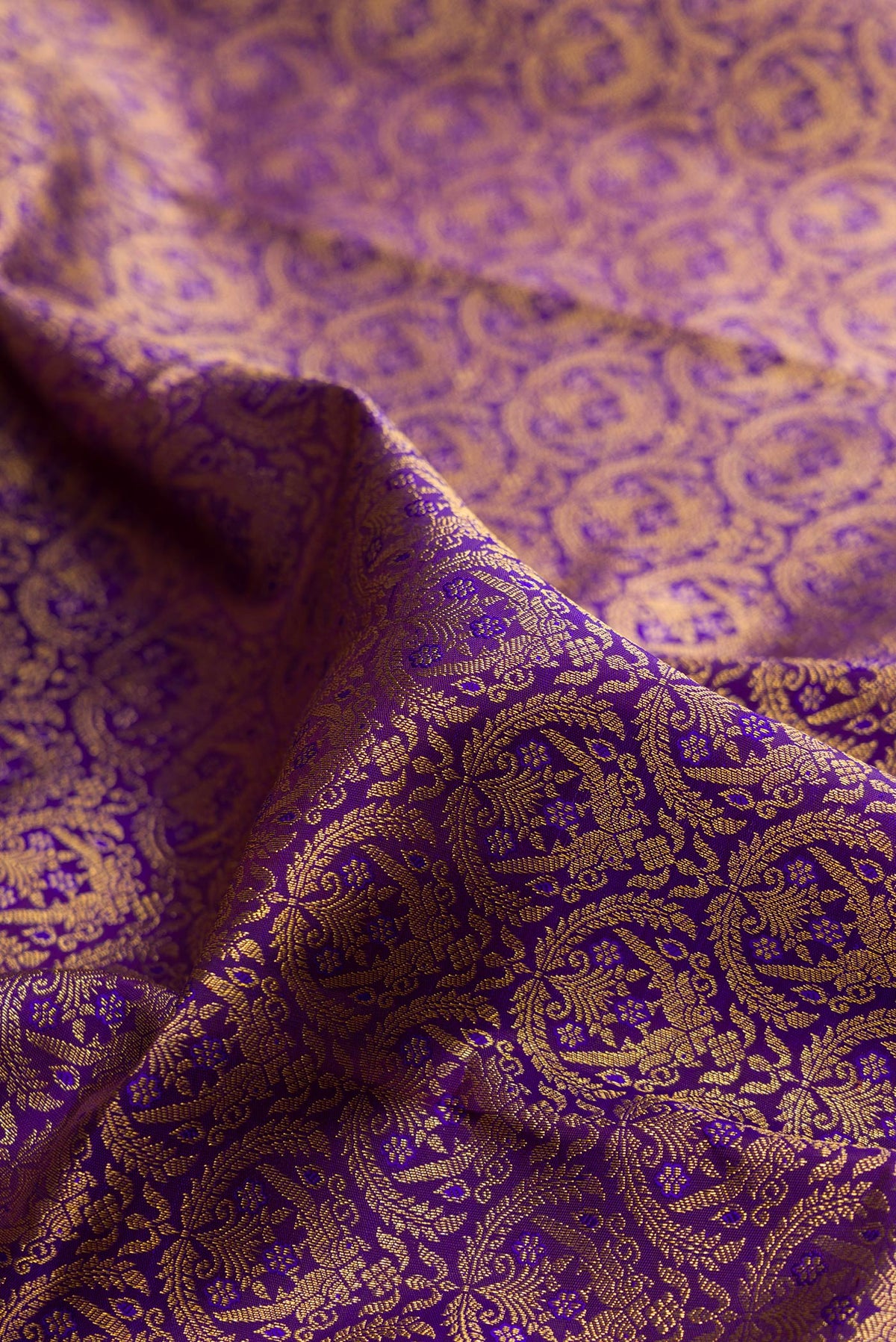 Close up of Pure Silk Violet Kanchipuram Saree with Zari Brocade on the body and Zari Border.  displaying folds