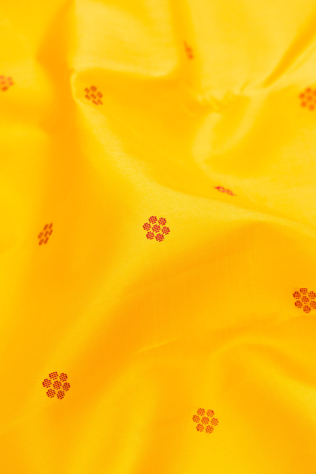 Close up of Pure Silk Pure Zari Yellow Kanjivaram Saree with Thread Butta on the body and One Side Border.  displaying folds