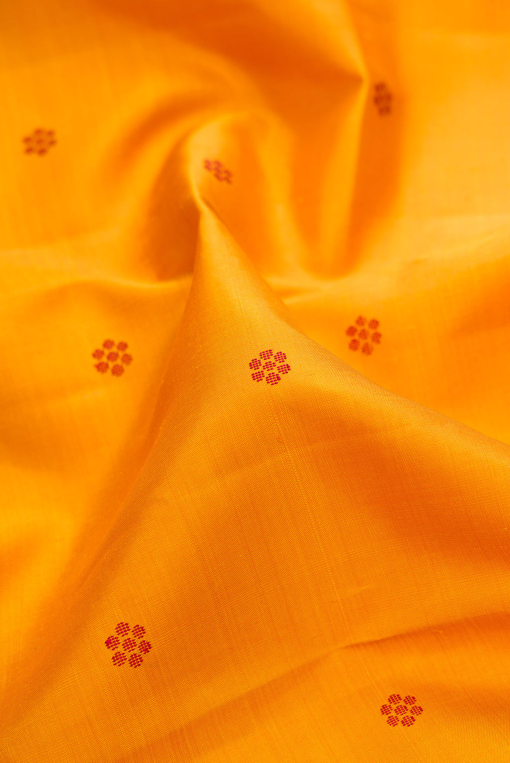 Close up of Pure Silk Pure Zari Mustard Kanjivaram Saree with Thread Butta on the body and One Side Border.  displaying folds