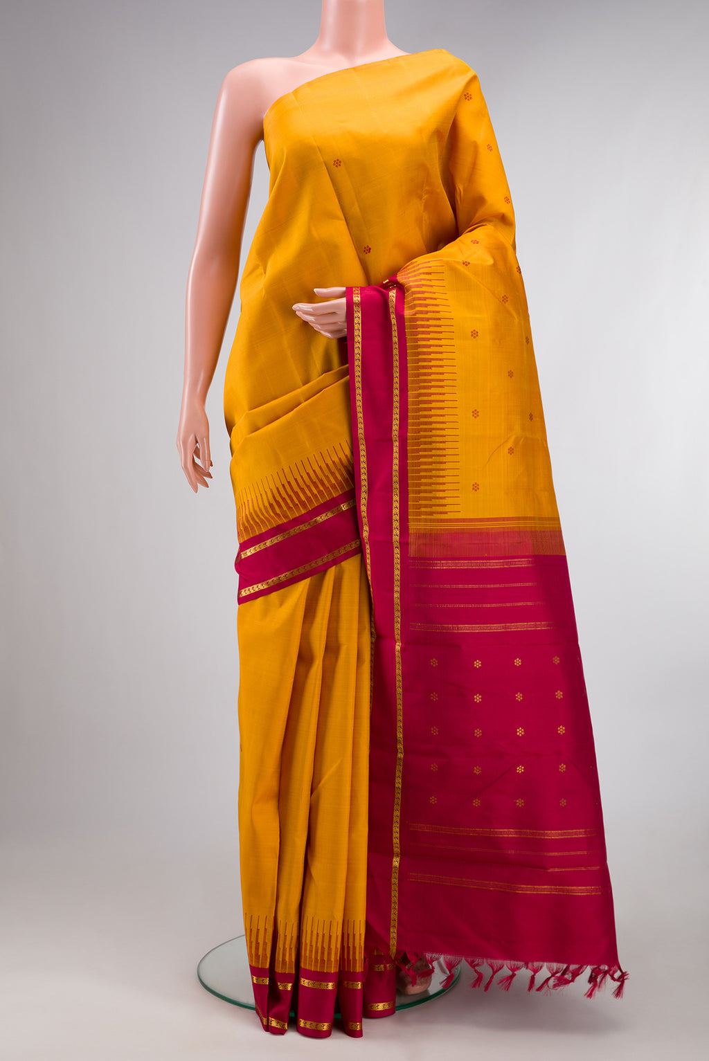 Pure Silk Pure Zari Mustard Kanjivaram Saree with Thread Butta on the body and One Side Border.  displayed on a mannequin
