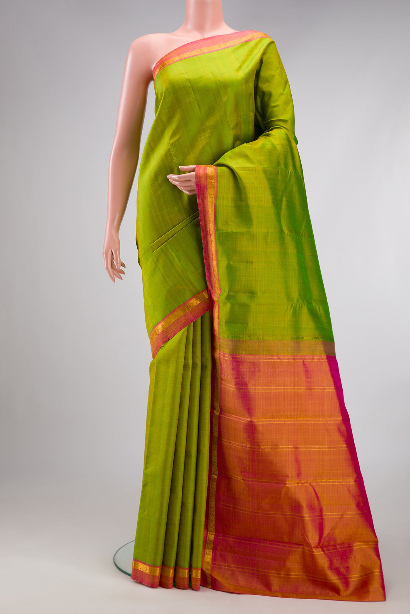 Parrot Green Kanjivaram Silk Saree with Plain Body and Zari Border.  displayed on a mannequin