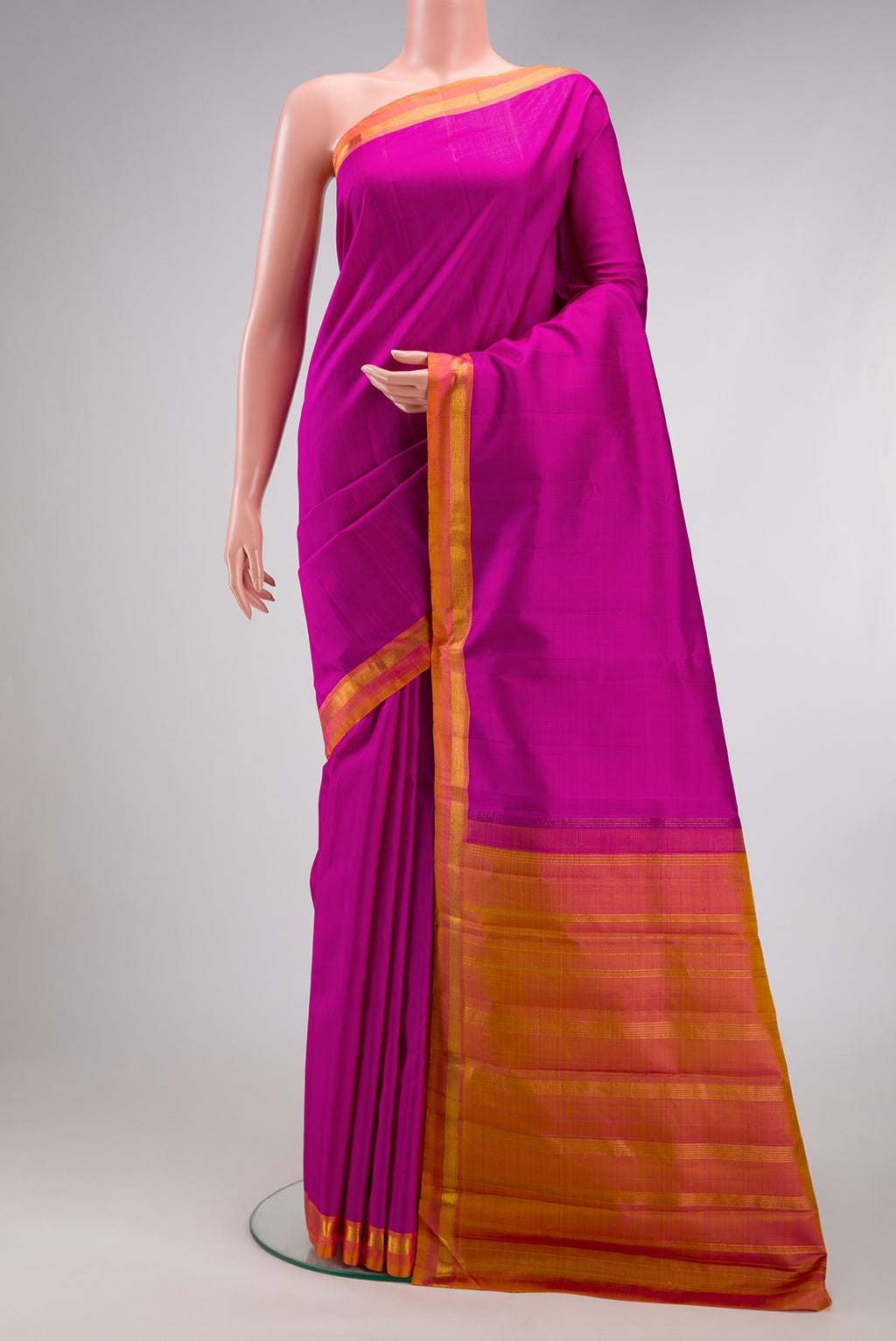 Magenta Kanjivaram Silk Saree with Plain Body and Zari Border.  displayed on a mannequin