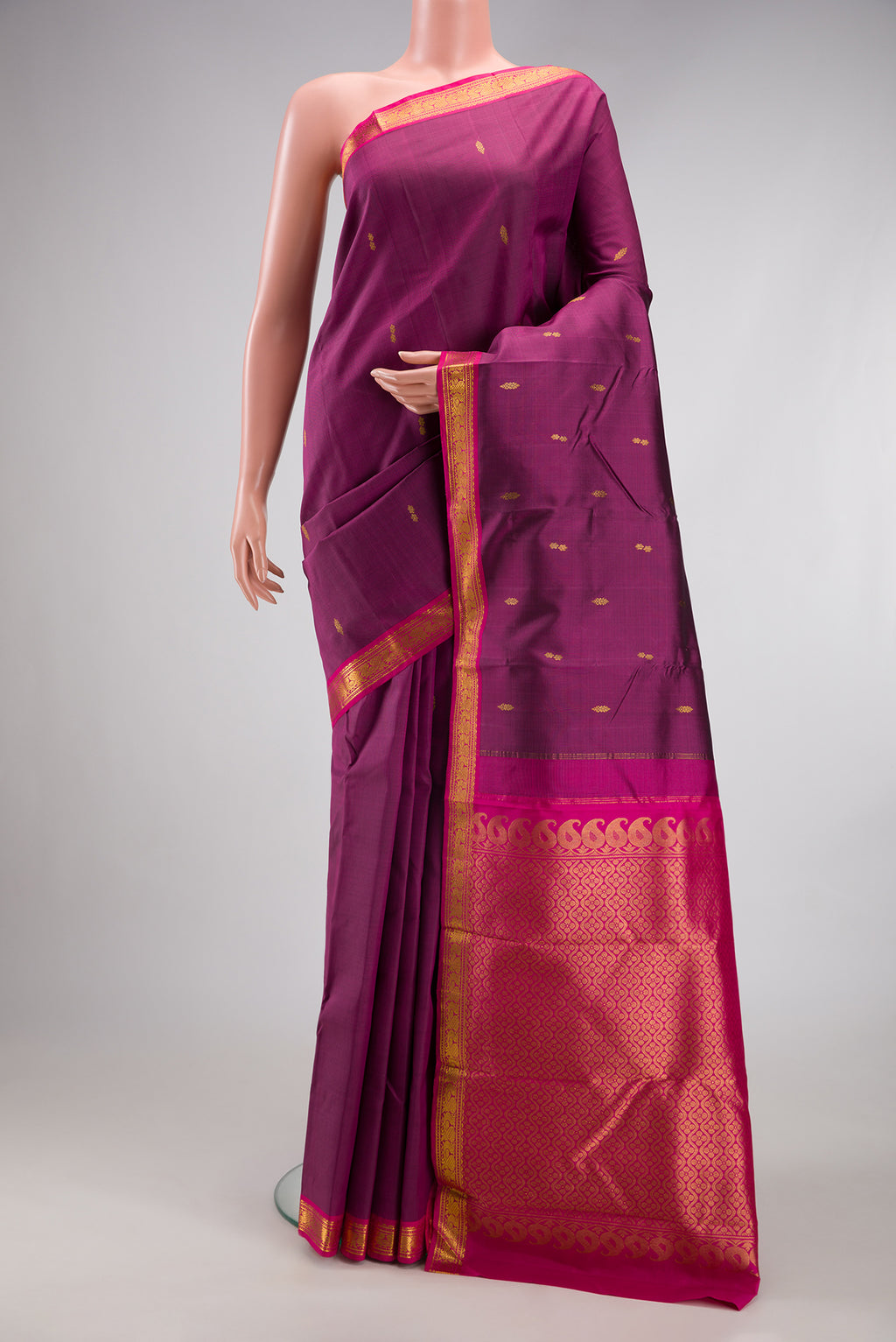 Magenta Kanchipuram Silk Saree with Zari Butta on the body and Zari Border.  displayed on a mannequin