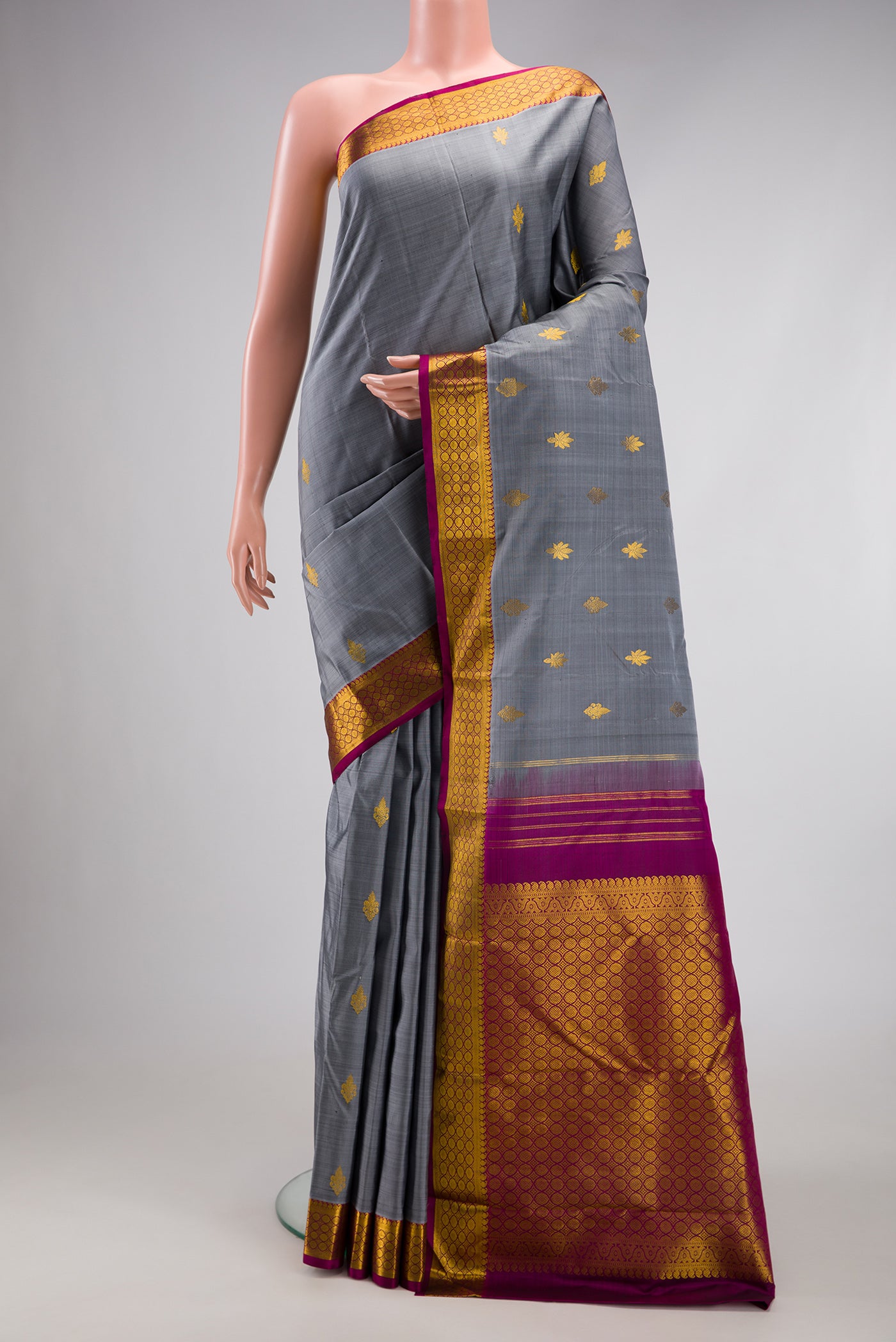 Grey Kanchipuram Silk Saree with Zari Butta on the body and Zari Border.  displayed on a mannequin
