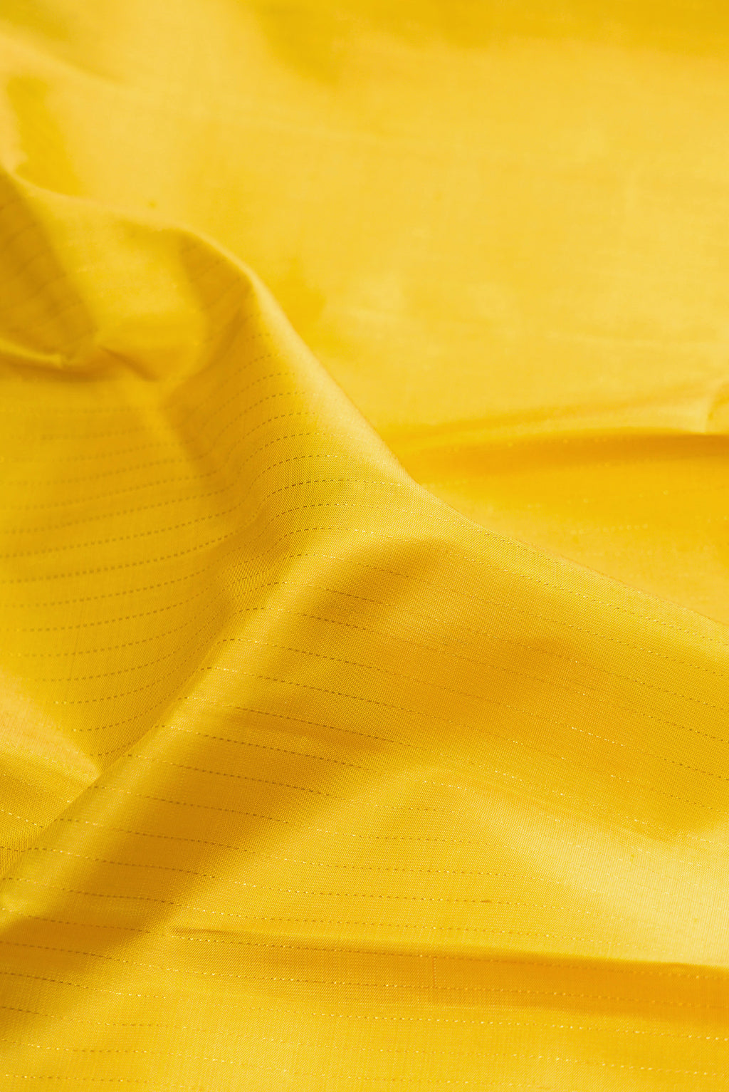 Close up of Lemon Yellow Kanjivaram Silk Saree with Stripes on the body and Zari Border.  displaying folds