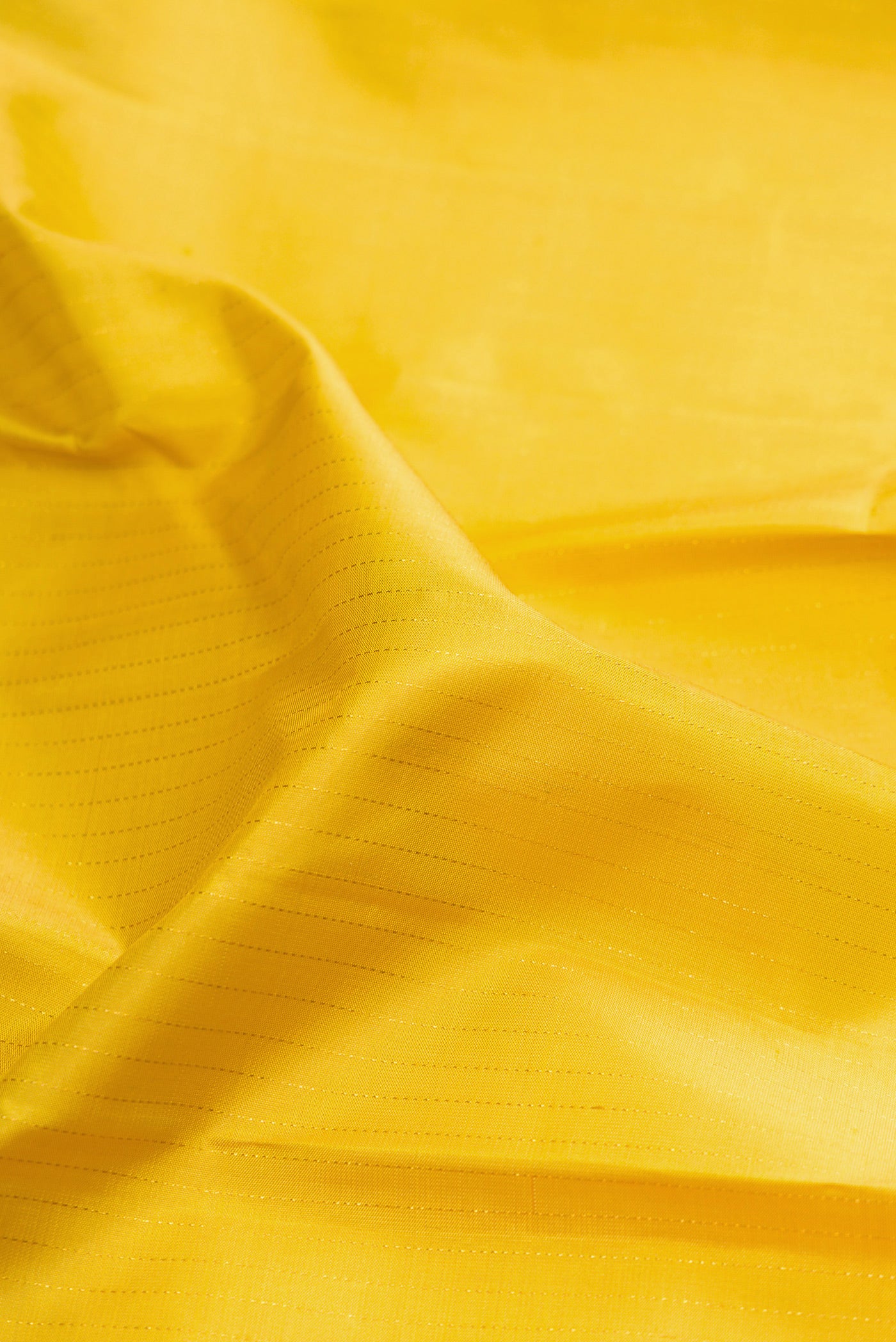 Close up of Lemon Yellow Kanjivaram Silk Saree with Stripes on the body and Zari Border.  displaying folds