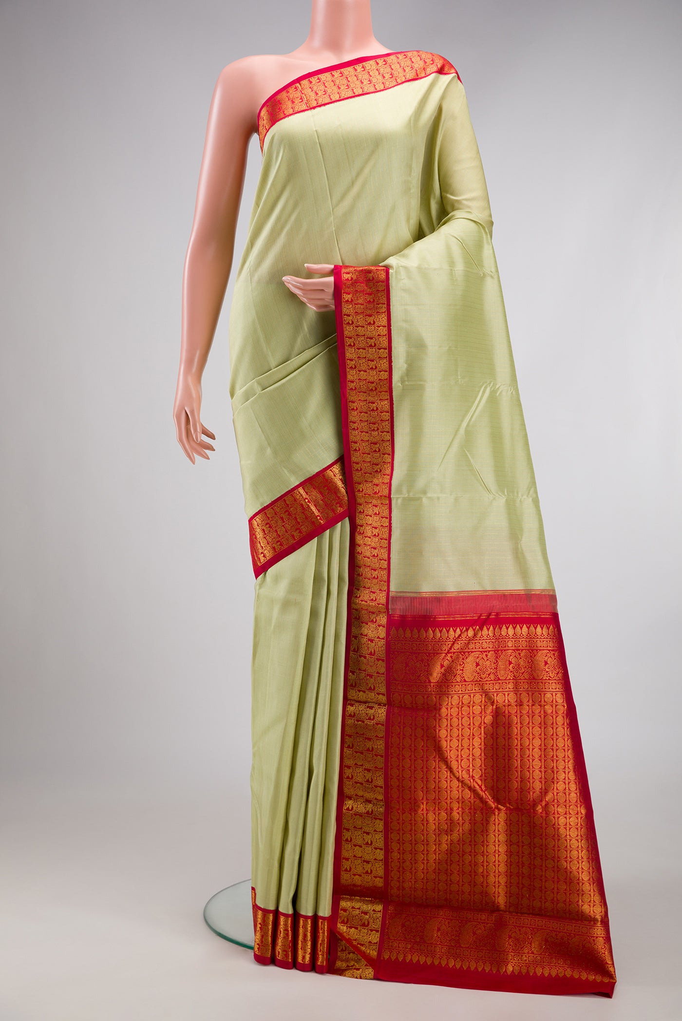 Pista Green Kanjivaram Silk Saree with Stripes on the body and Zari Border.  displayed on a mannequin