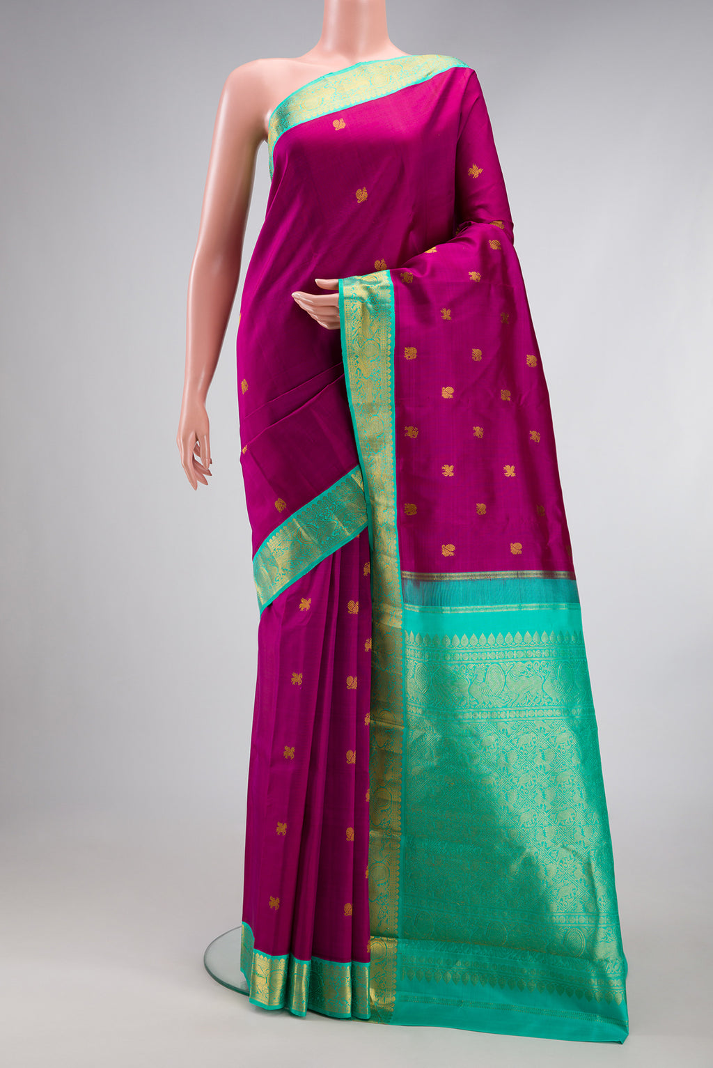 Magenta Kanjivaram Silk Saree with Zari Butta on the body and Zari Border.  displayed on a mannequin