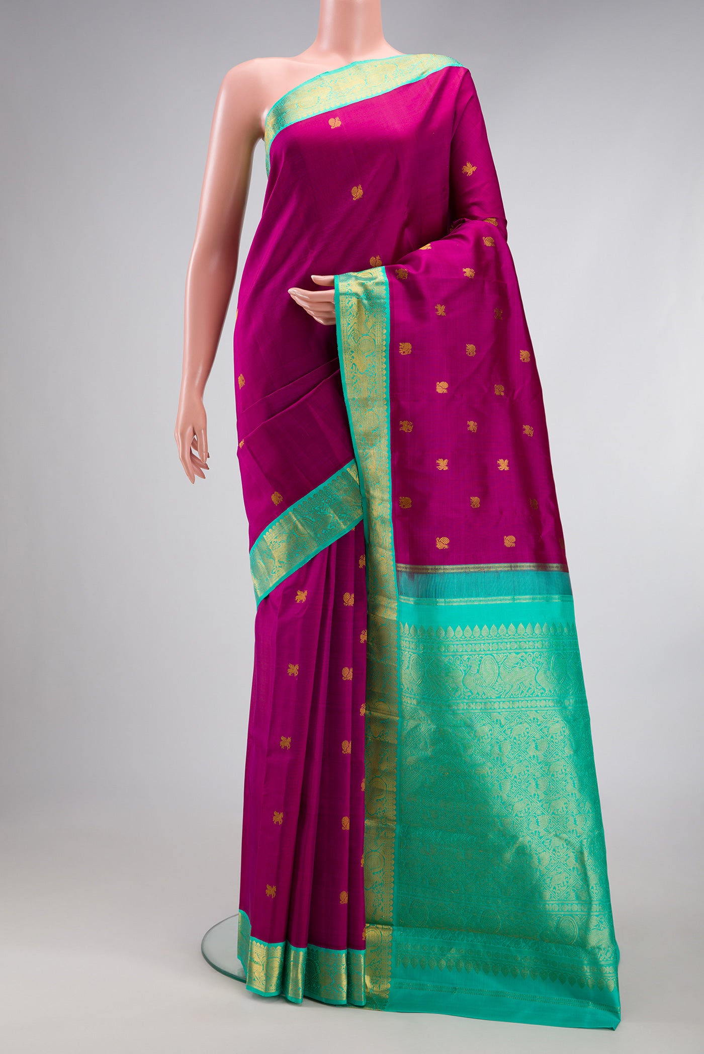 Magenta Kanjivaram Silk Saree with Zari Butta on the body and Zari Border.  displayed on a mannequin