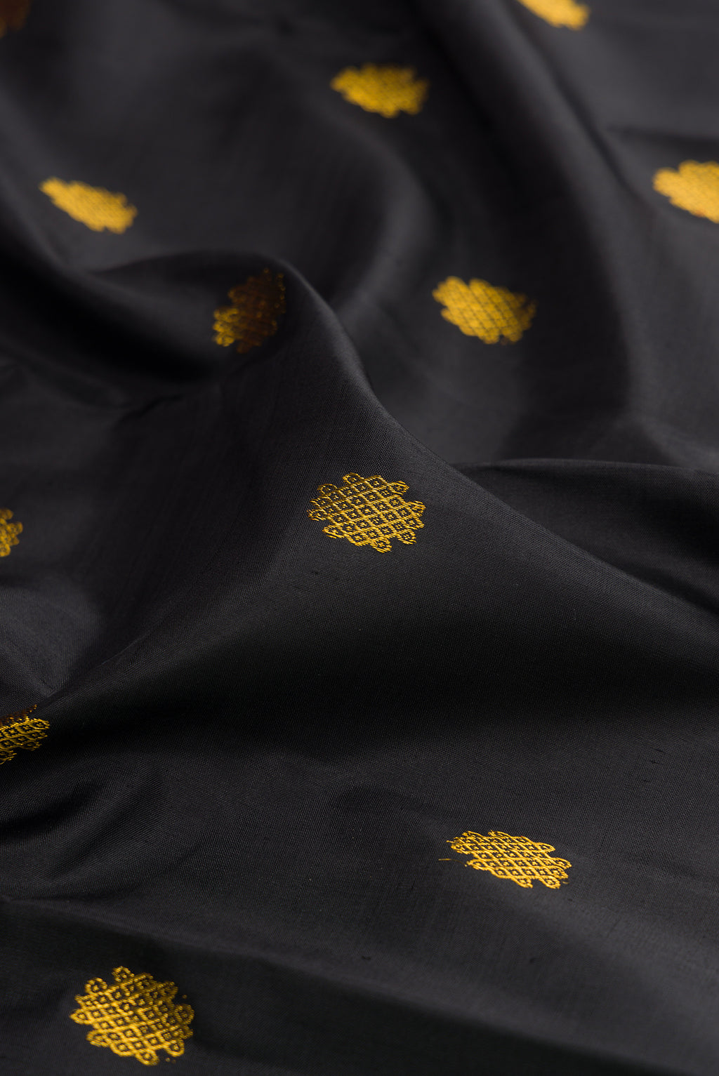 Close up of Black Kanjivaram Silk Saree with Zari Butta on the body and Fancy Border.  displaying folds