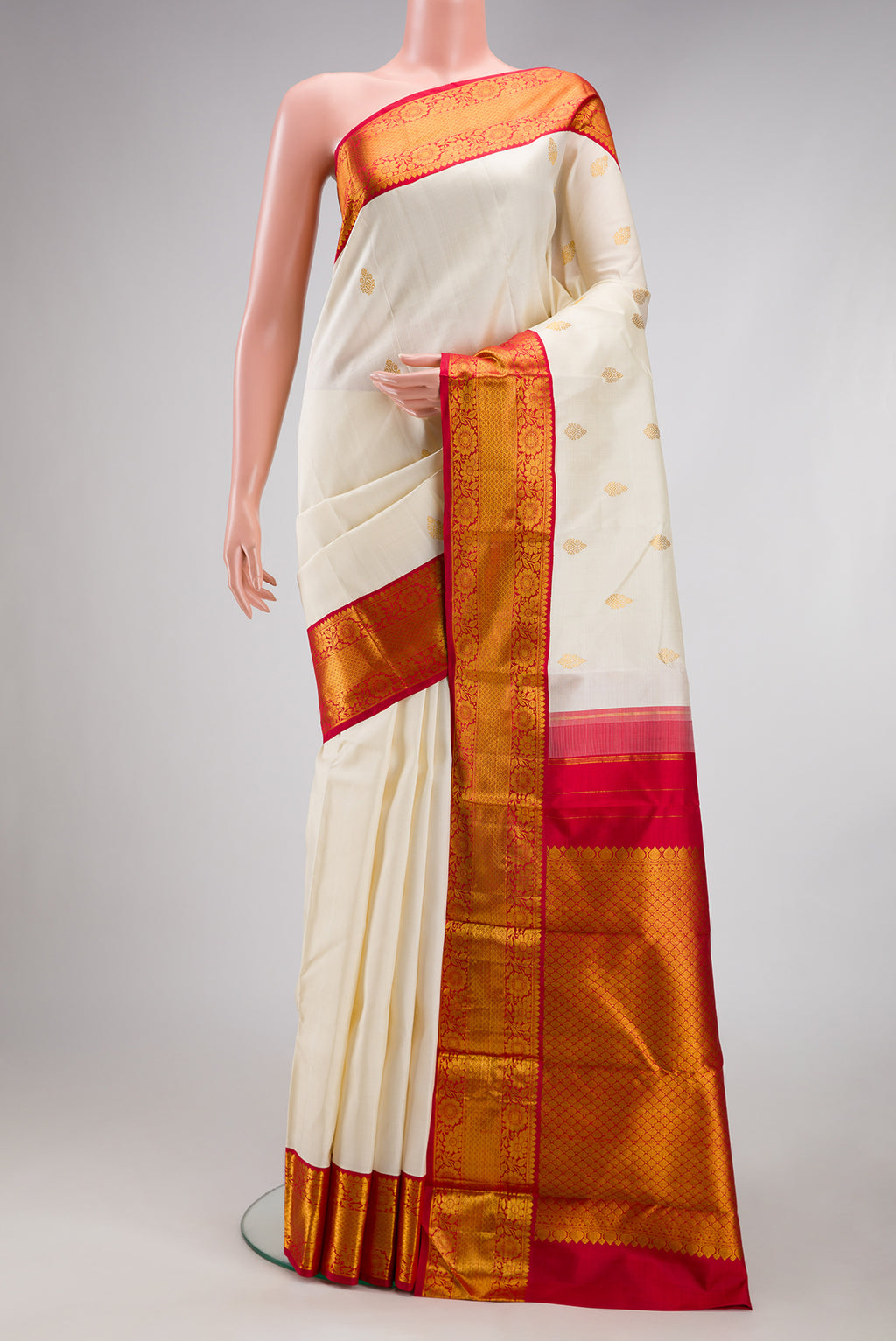 Off White Kanjivaram Silk Saree with Zari Butta on the body and Zari Border.  displayed on a mannequin