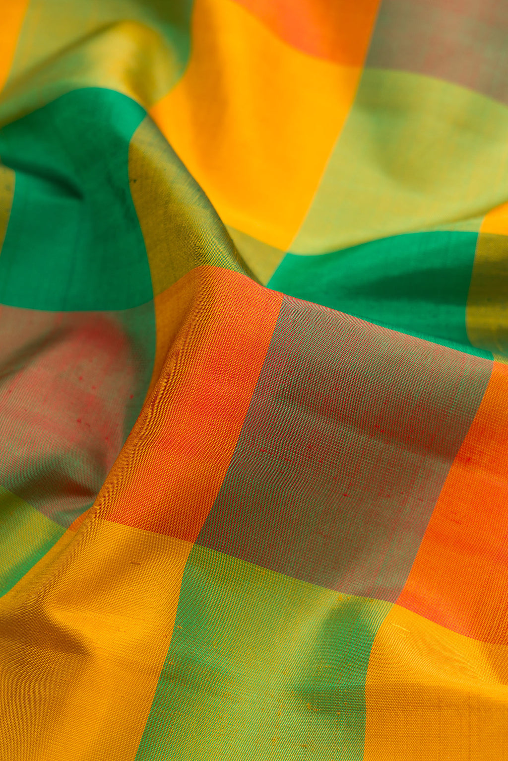 Close up of Multi Color Kanchipuram Silk Saree with Checked design on the body and Fancy Border.  displaying folds