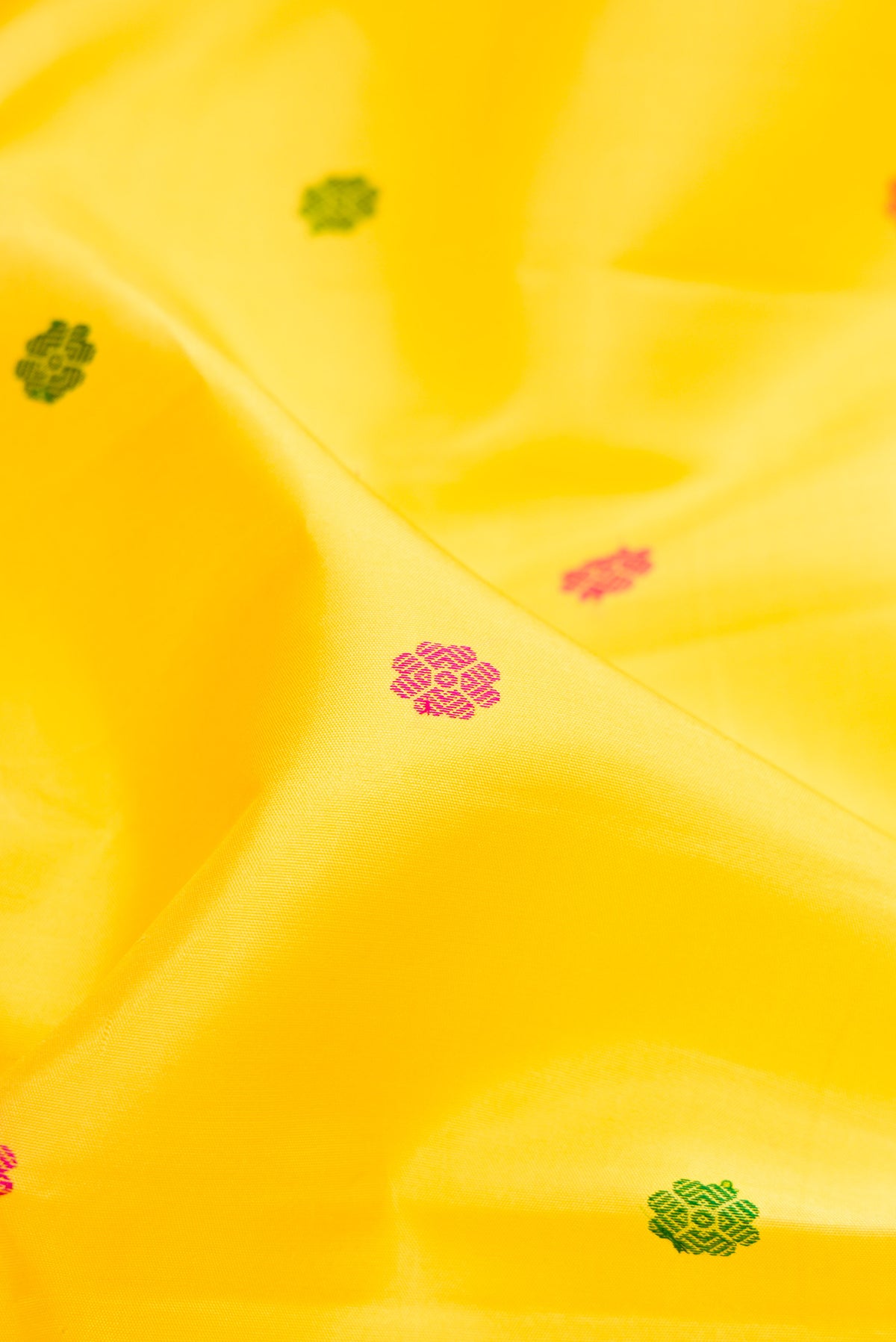 Close up of Yellow Kanjivaram Silk Saree with Thread Butta on the body and Thread Border.  displaying folds