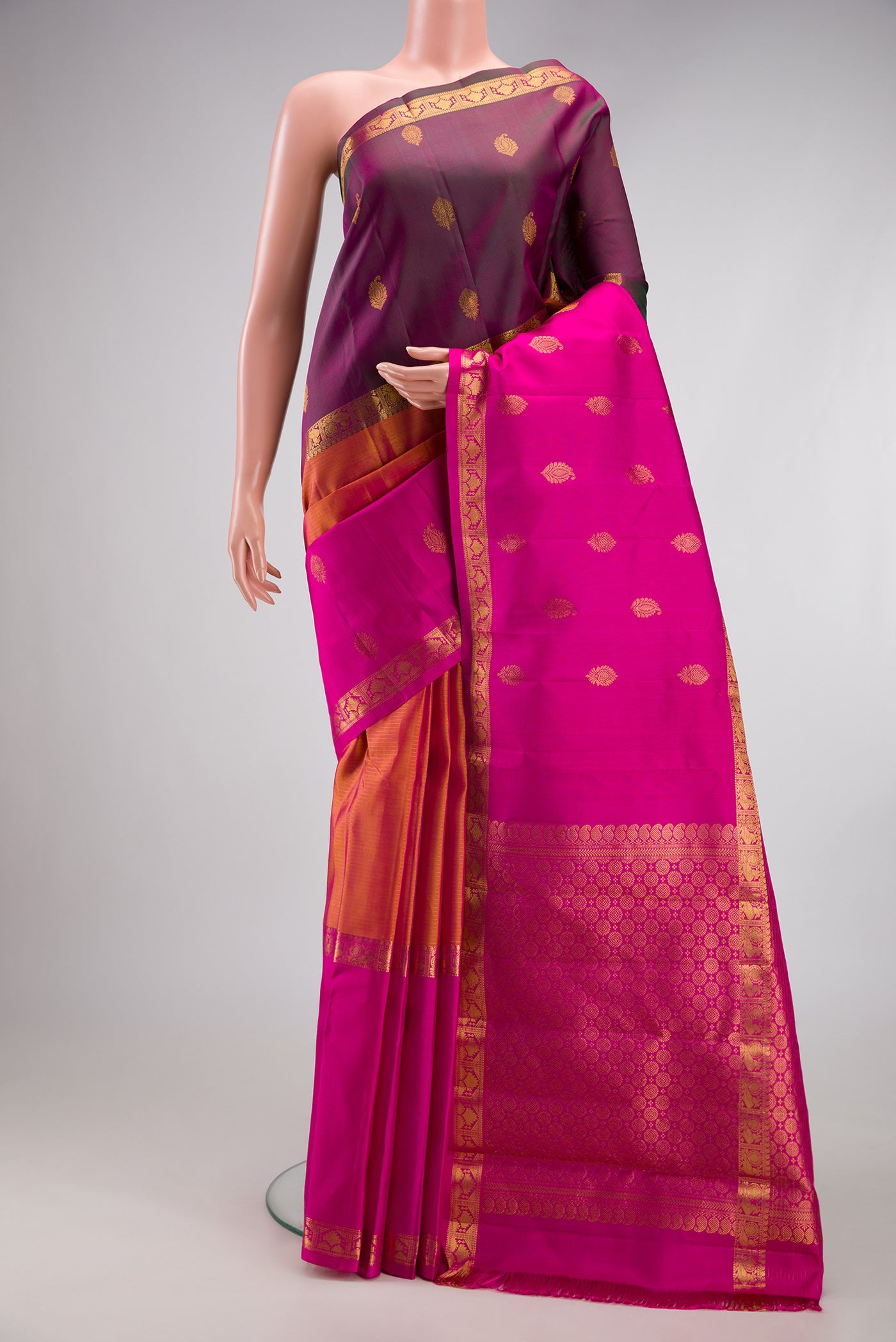 Orange Kanjivaram Silk Saree with Stripes on the body and Ganga Jamuna Border.  displayed on a mannequin