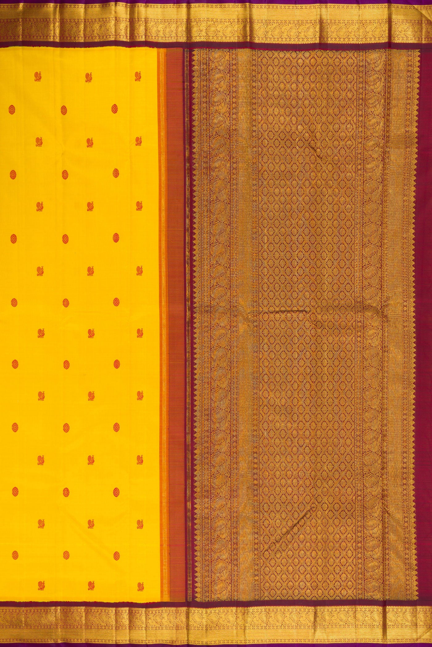 Close up image of the pallu of Yellow Kanjivaram Silk Saree with Thread Butta on the body and Zari Border. 