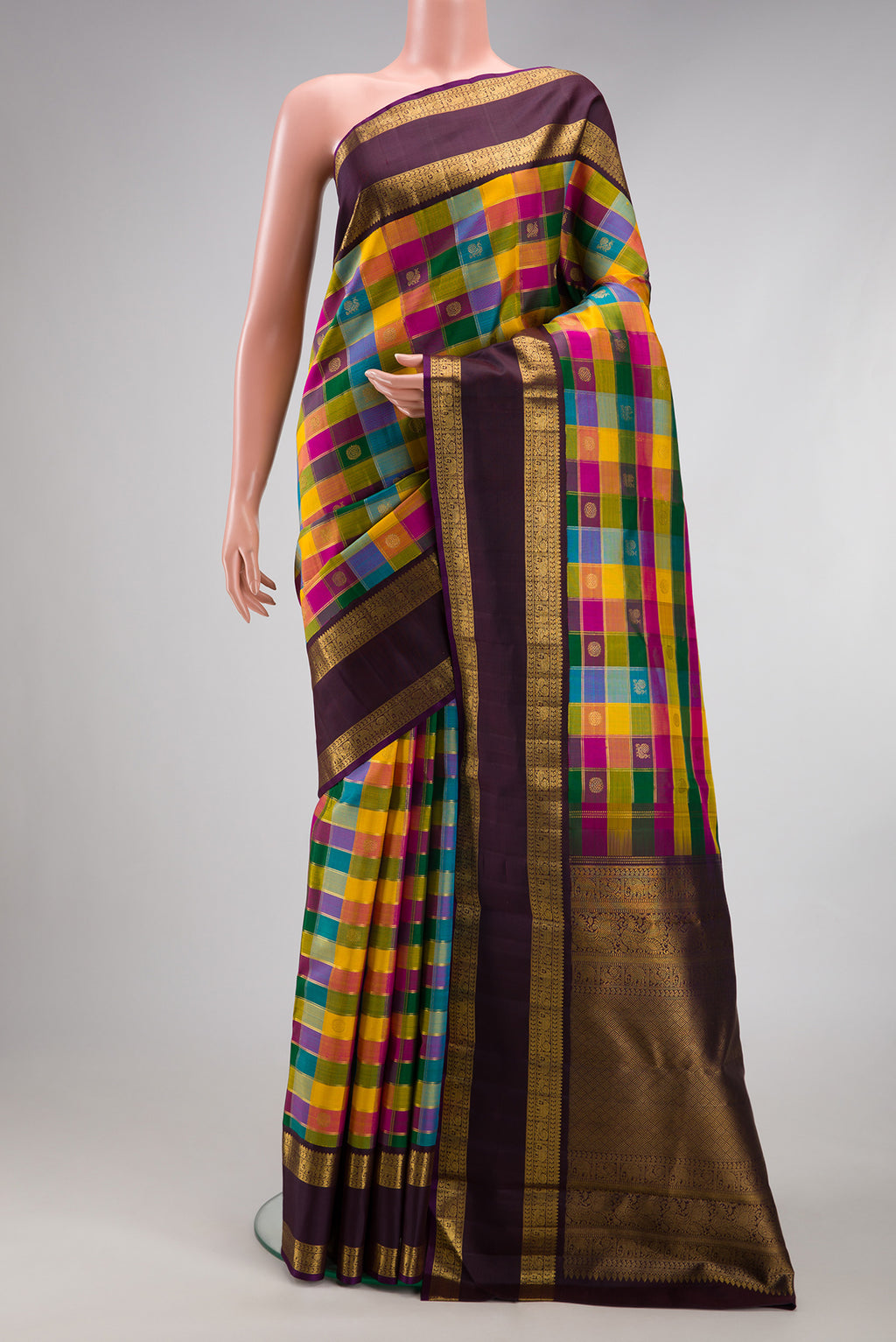 Multi Color Kanchipuram Silk Saree with Checked design on the body and Zari Border.  displayed on a mannequin
