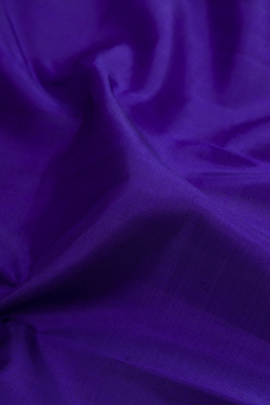 Close up of Royal Blue Kanjivaram Silk Saree with Plain Body and Zari Border.  displaying folds