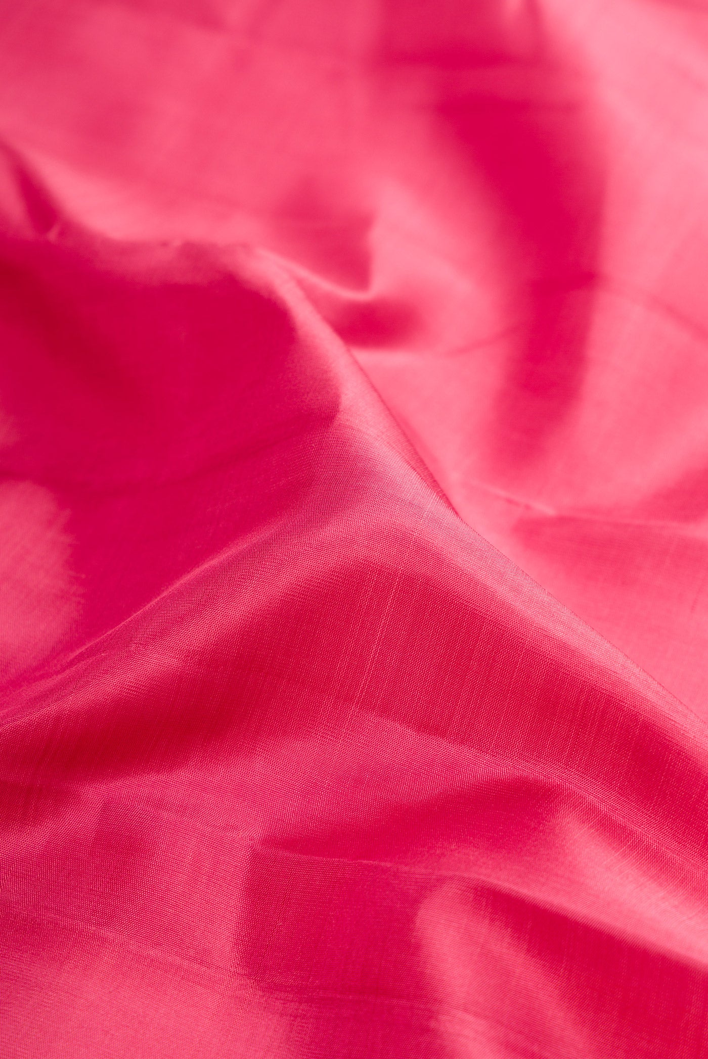 Close up of Rose pink Kanjivaram Silk Saree with Plain Body and Zari Border.  displaying folds