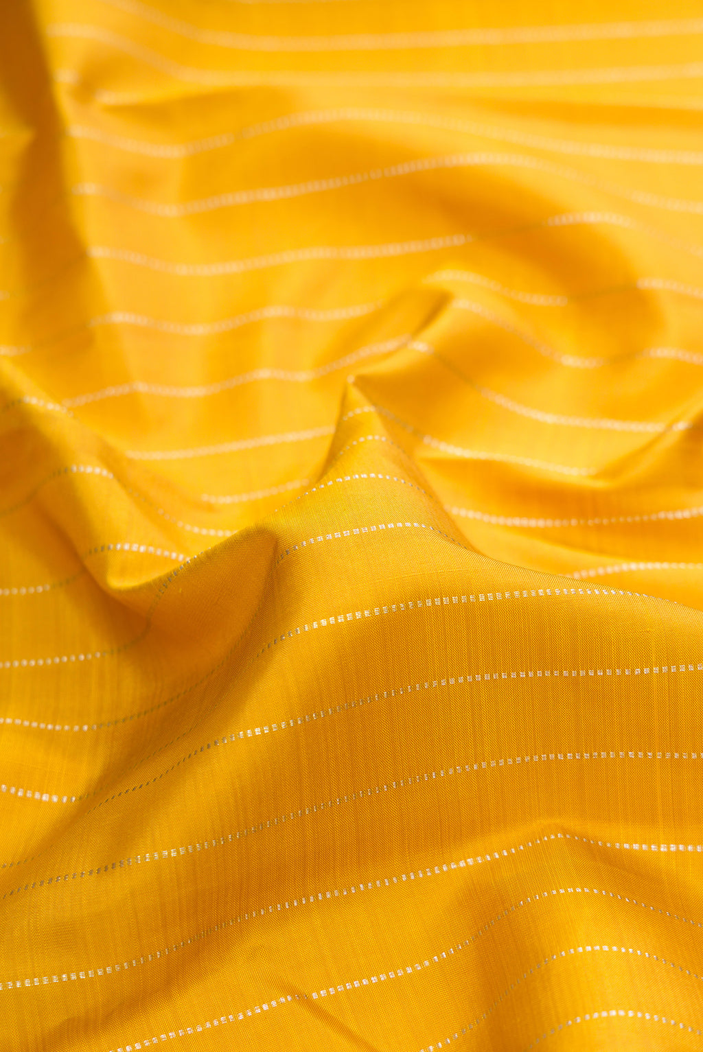 Close up of Pure Silk Mustard Kanjivaram Saree with Stripes on the body and Without Border.  displaying folds