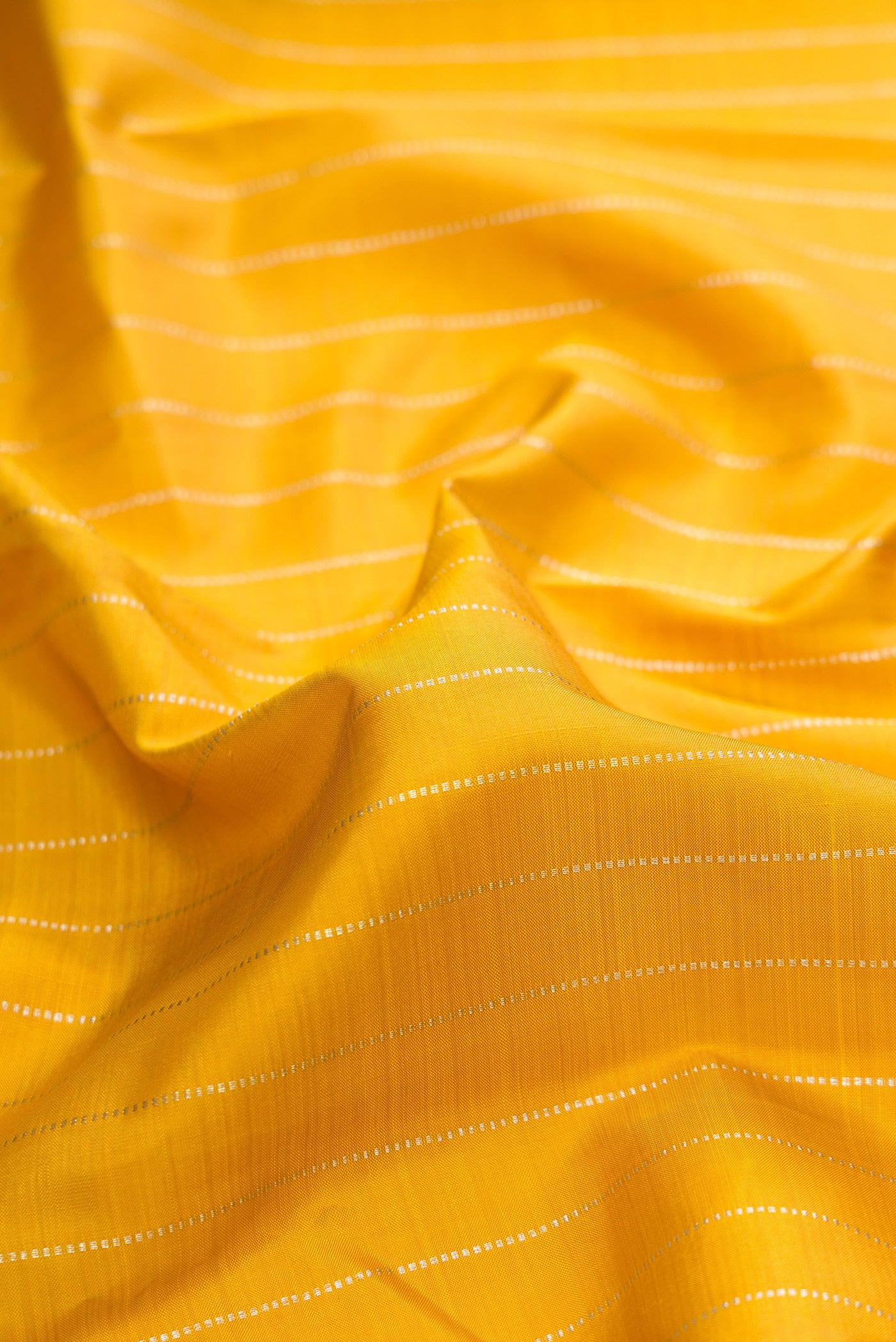 Close up of Pure Silk Mustard Kanjivaram Saree with Stripes on the body and Without Border.  displaying folds