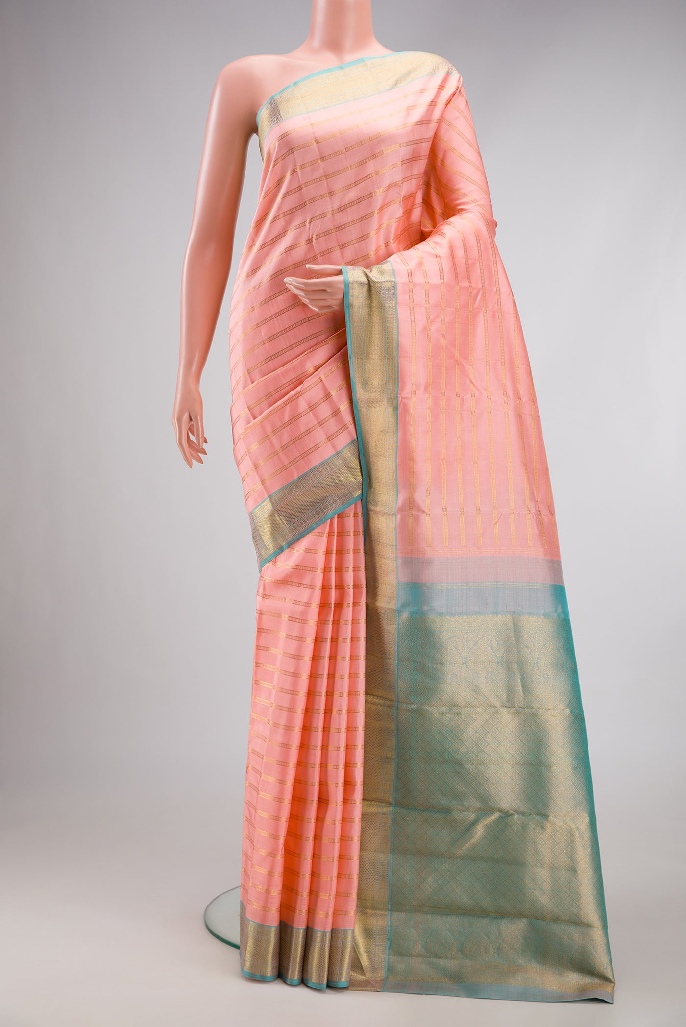 Peach Kanjivaram Silk Saree with Stripes on the body and Zari Border.  displayed on a mannequin