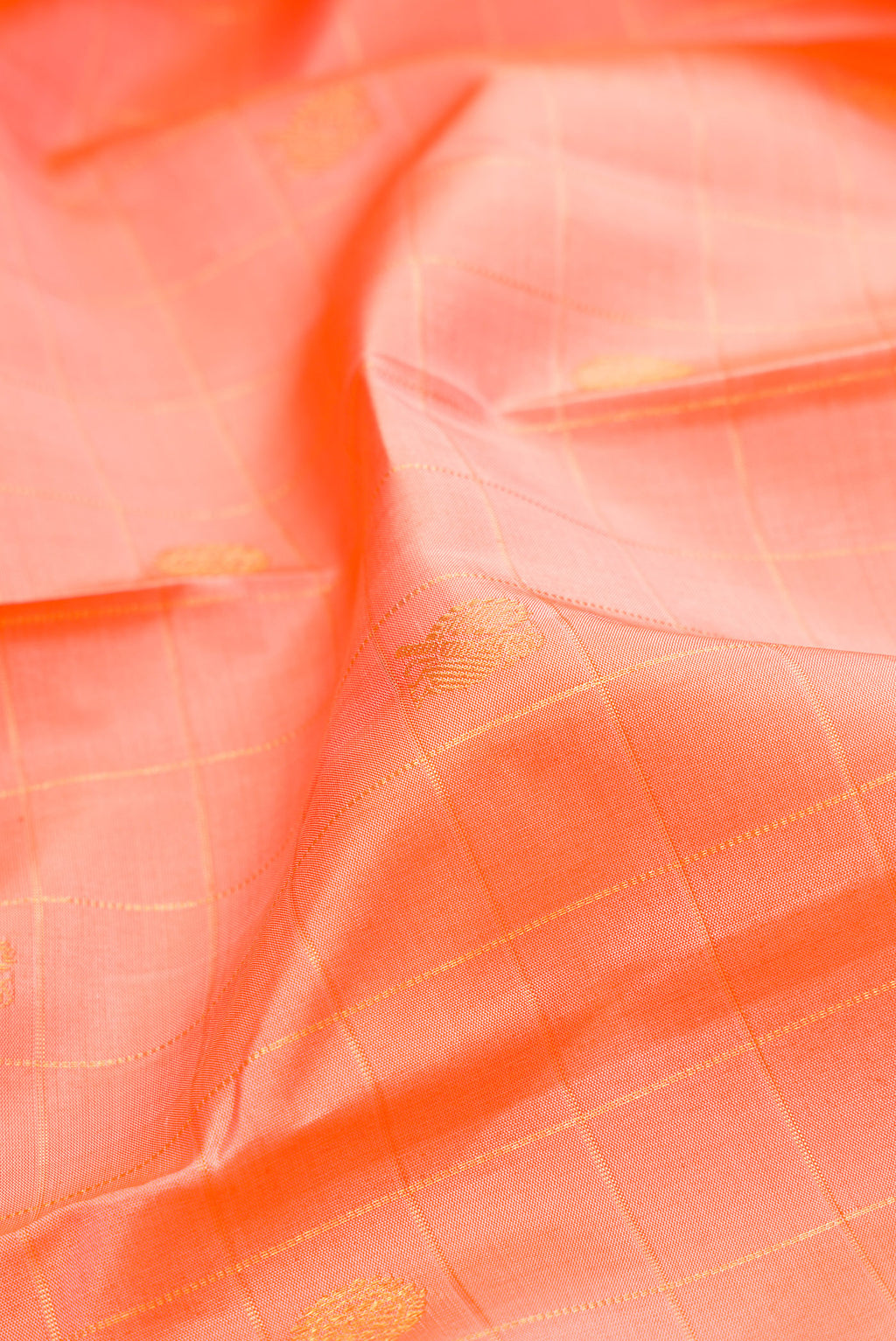 Close up of Golden Peach Kanchipuram Silk Saree with Checked design on the body and Plain Border.  displaying folds