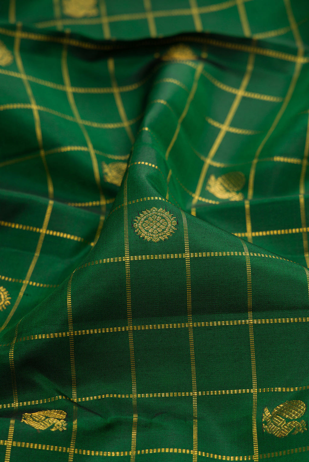 Close up of Bottle Green Kanjivaram Silk Saree with Checked design on the body and Zari Border.  displaying folds